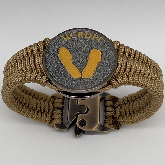 Thin, narrow, flexible and comfortable braided United States Marine Corps Recruit Depot Yellow Footprints bracelet featuring a black nickel plated UV enamel painted medallion replica of an actual set of USMC footprints, a gold Cobra style tactical buckle and woven with gold Type-1 paracord.