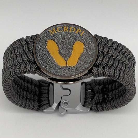 Thin, wide, flexible and comfortable braided United States Marine Corps Recruit Depot Yellow Footprints bracelet featuring a black nickel plated UV enamel painted medallion replica of an actual set of USMC recruit depot footprints, a silver Cobra style tactical buckle and woven with Charcoal Gray Type-1 paracord.