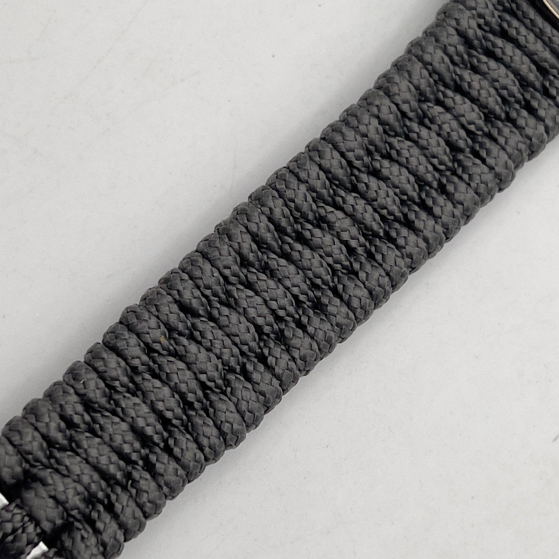 Thin, narrow, flexible and comfortable braided United States Marine Corps Recruit Depot Yellow Footprints bracelet featuring a black nickel plated UV enamel painted medallion replica of an actual set of USMC footprints, a silver Cobra style tactical buckle and woven with Charcoal Gray Type-1 paracord.