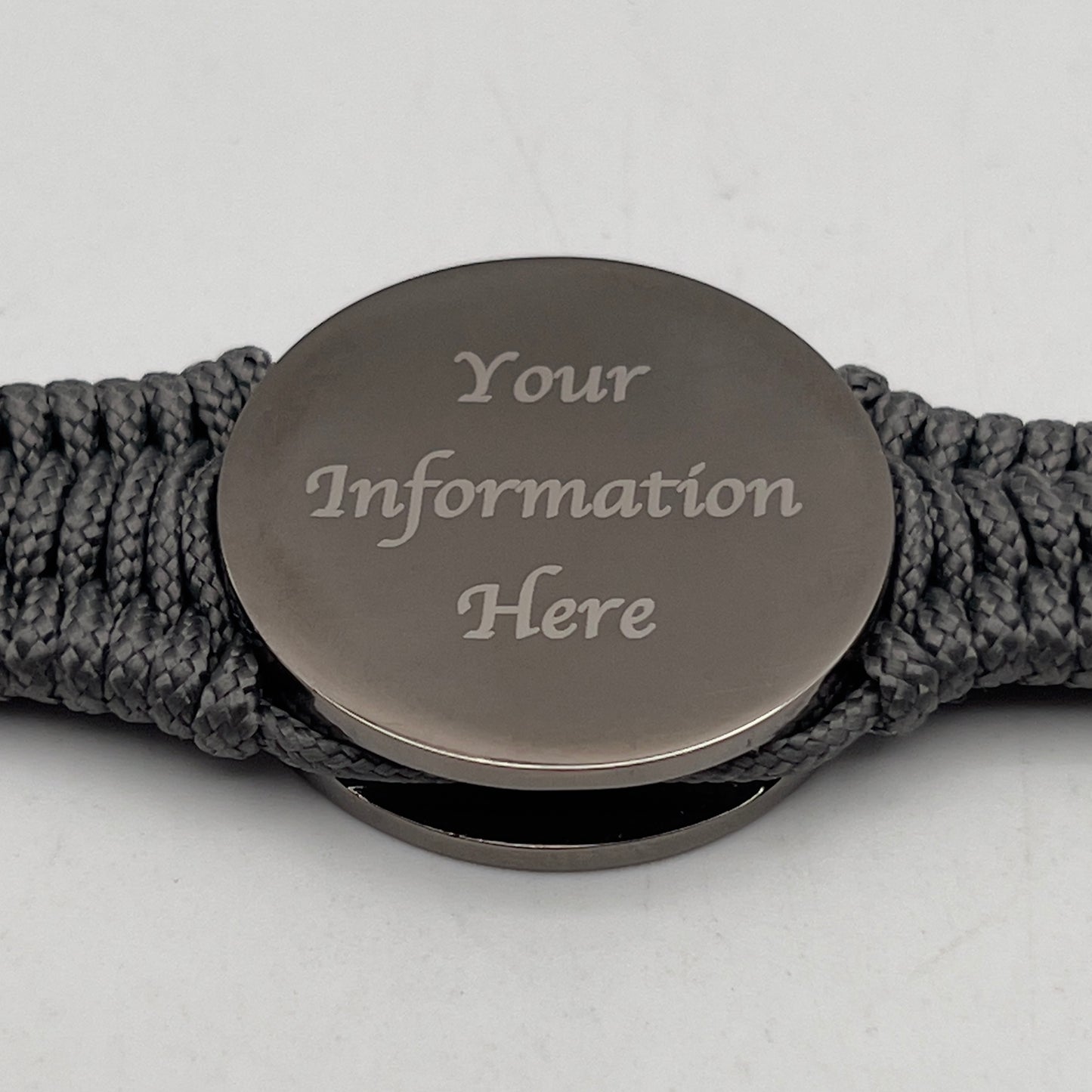 Thin, narrow, flexible and comfortable braided United States Marine Corps Recruit Depot Yellow Footprints bracelet featuring a black nickel plated UV enamel painted medallion replica of an actual set of USMC footprints, a silver Cobra style tactical buckle and woven with Charcoal Gray Type-1 paracord.