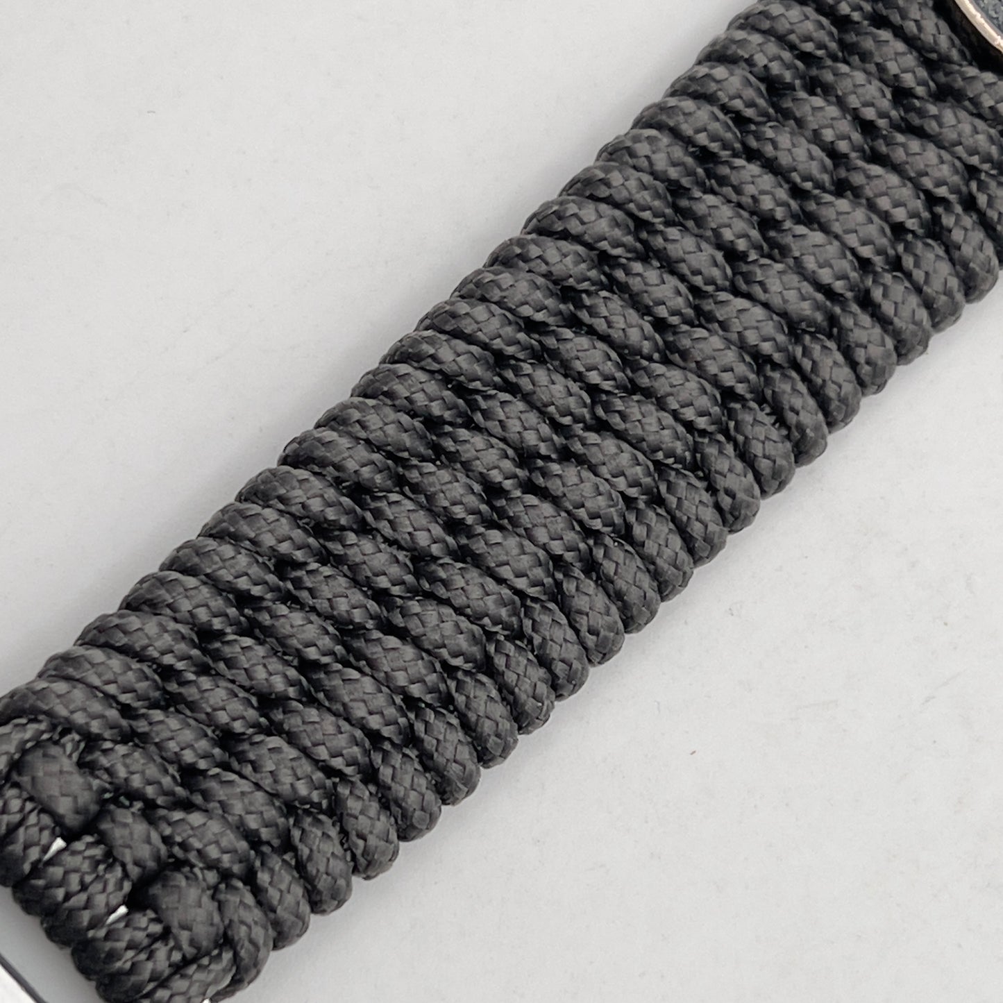 Thin, wide, flexible and comfortable braided United States Marine Corps Recruit Depot Yellow Footprints bracelet featuring a black nickel plated UV enamel painted medallion replica of an actual set of USMC footprints, a silver Cobra style tactical buckle and woven with Charcoal Gray Type-1 paracord.