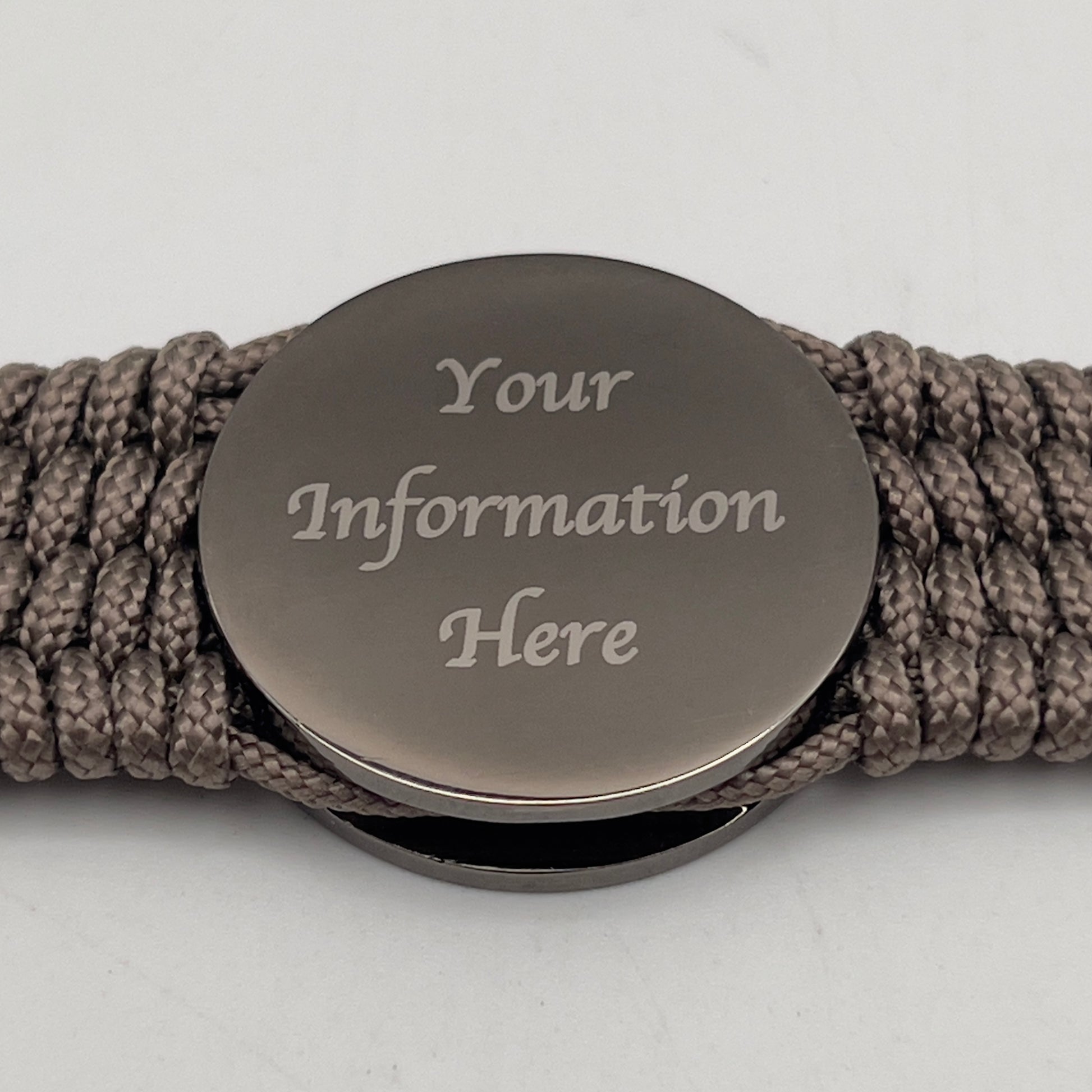 Thin, wide, flexible and comfortable braided United States Marine Corps Recruit Depot Yellow Footprints bracelet featuring a black nickel plated UV enamel painted medallion replica of an actual set of USMC recruit depot footprints, a gold Cobra style tactical buckle and woven with tan Type-1 paracord.