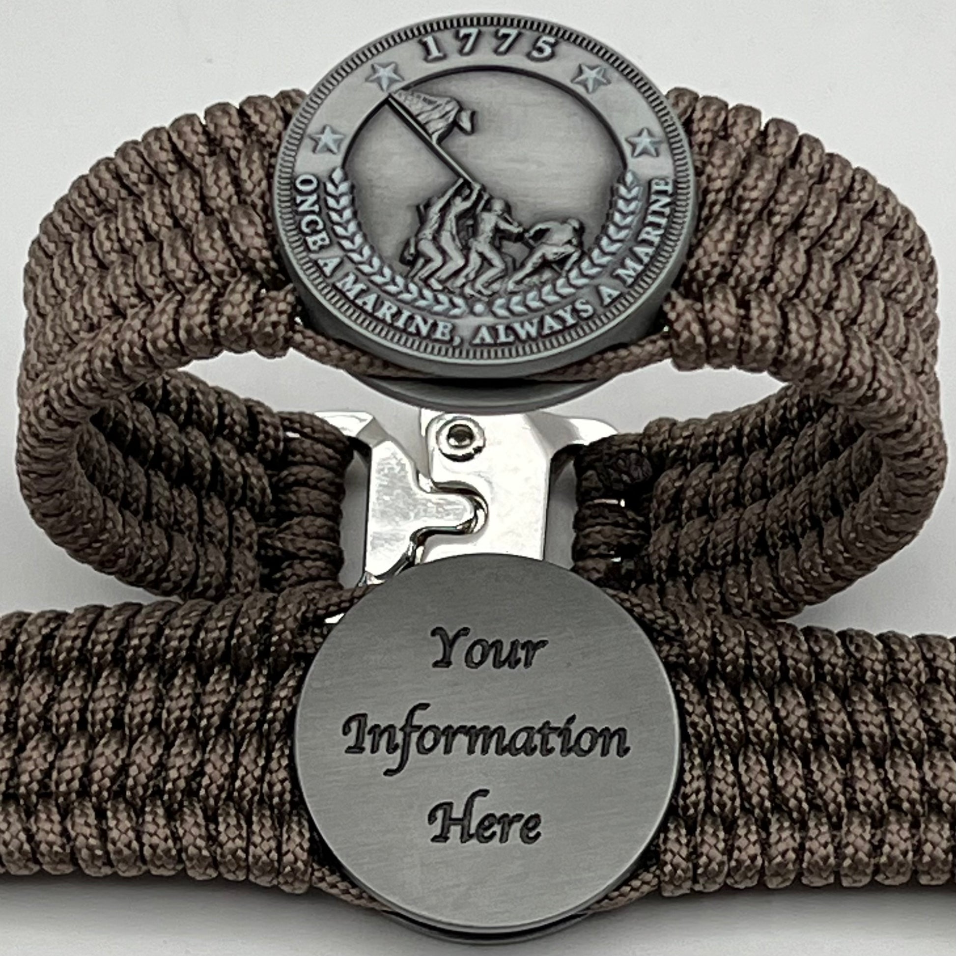 Thin, wide, flexible and comfortable braided United States Marine Corps Iwo Jima bracelet featuring an antique silver plated Iwo Jima flag raising medallion, a silver Cobra style tactical buckle and woven with tan type-1 paracord.