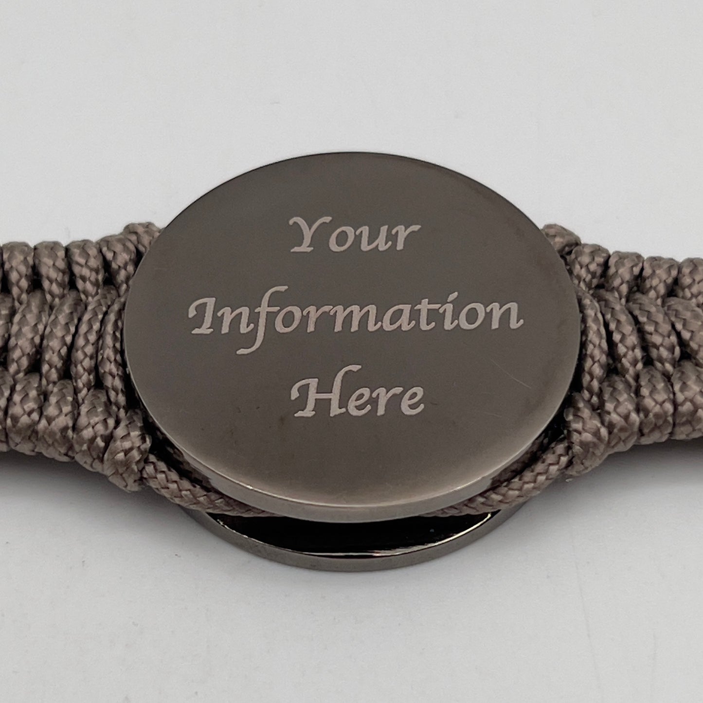 Thin, narrow, flexible and comfortable braided United States Marine Corps Recruit Depot Yellow Footprints bracelet featuring a black nickel plated UV enamel painted medallion replica of an actual set of USMC recruit depot footprints, a gold Cobra style tactical buckle and woven with tan Type-1 paracord.