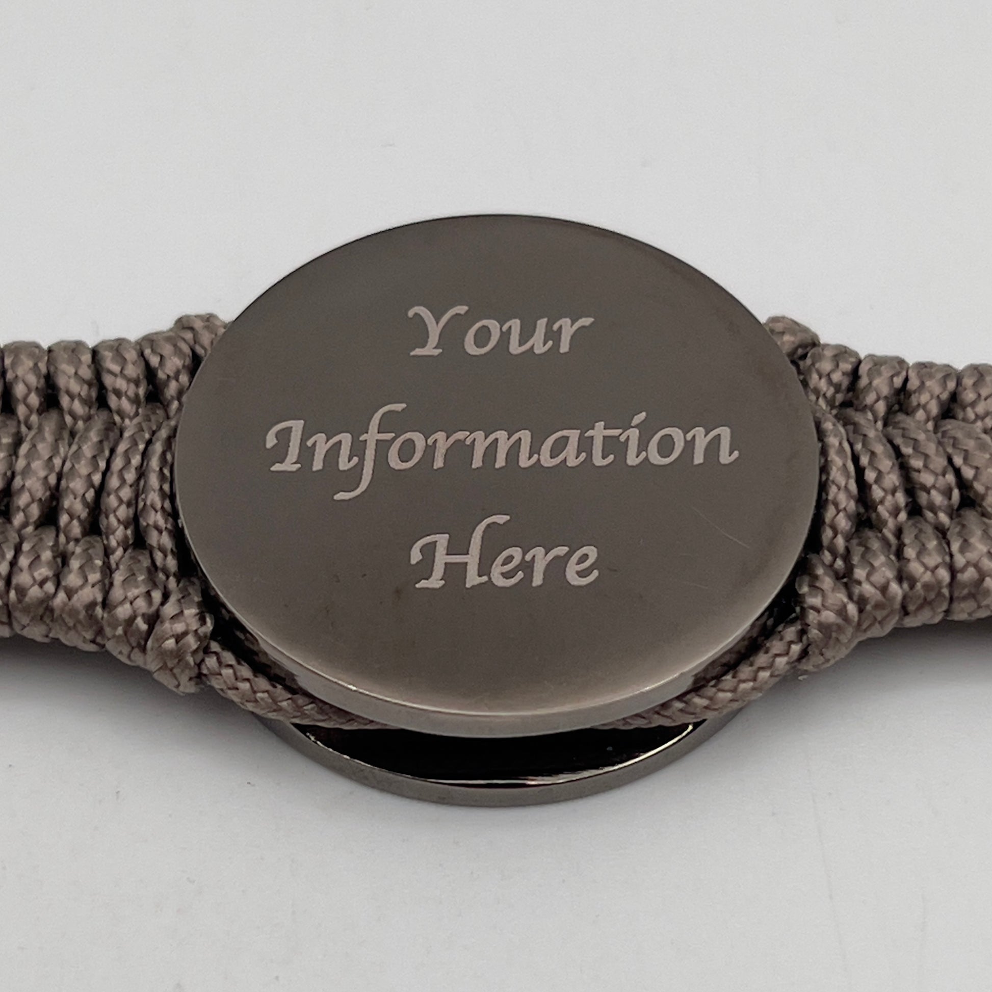 Thin, narrow, flexible and comfortable braided United States Marine Corps Recruit Depot Yellow Footprints bracelet featuring a black nickel plated UV enamel painted medallion replica of an actual set of USMC recruit depot footprints, a gold Cobra style tactical buckle and woven with tan Type-1 paracord.
