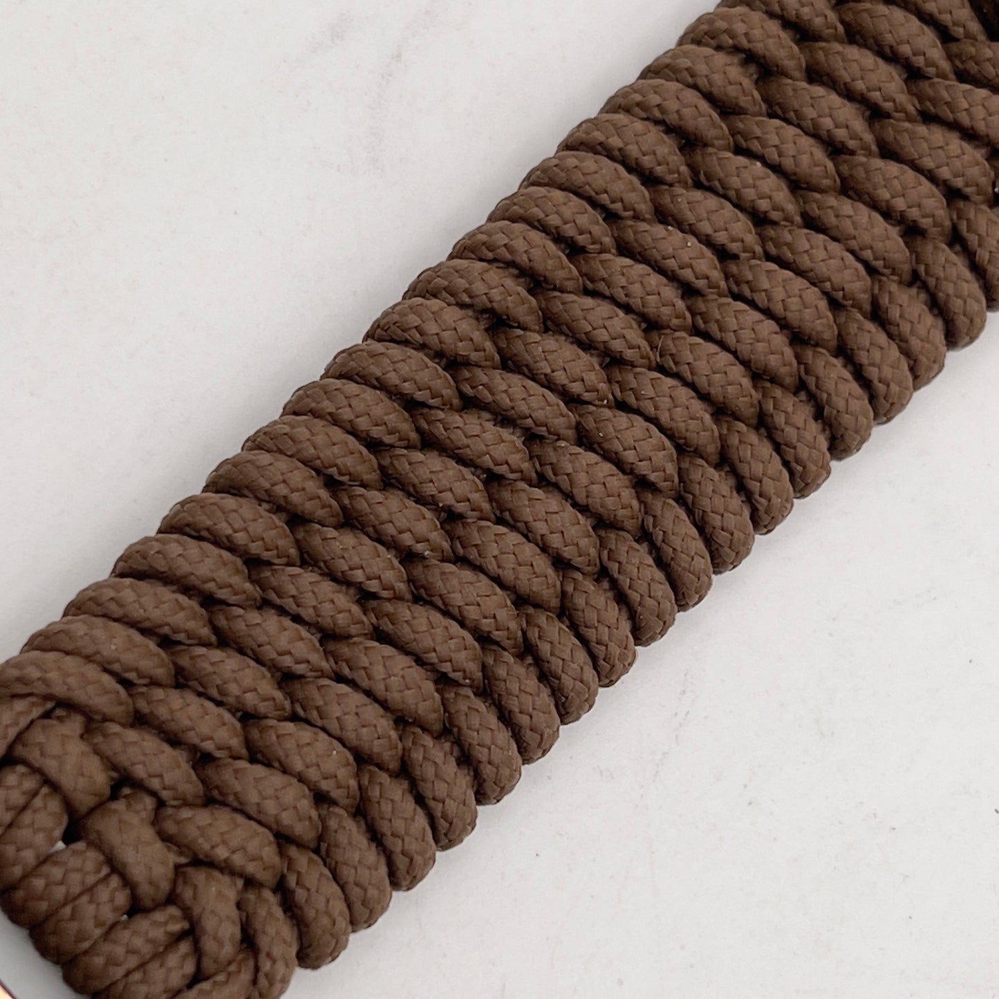 Thin, wide, flexible and comfortable braided United States Marine Corps Recruit Depot Yellow Footprints bracelet featuring a black nickel plated UV enamel painted medallion replica of an actual set of USMC footprints, a gold Cobra style tactical buckle and woven with Coyote Brown Type-1 paracord.