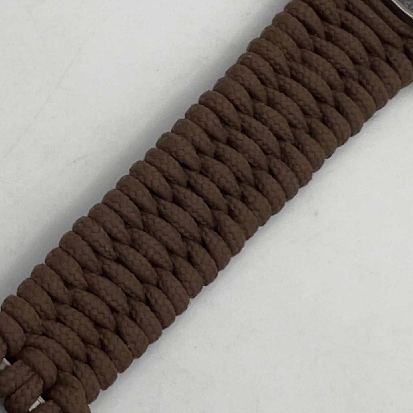 Thin, narrow, flexible and comfortable braided United States Marine Corps Recruit Depot Yellow Footprints bracelet featuring a black nickel plated UV enamel painted medallion replica of an actual set of USMC recruit depot footprints, a gold Cobra style tactical buckle and woven with Coyote Brown type-1 paracord.