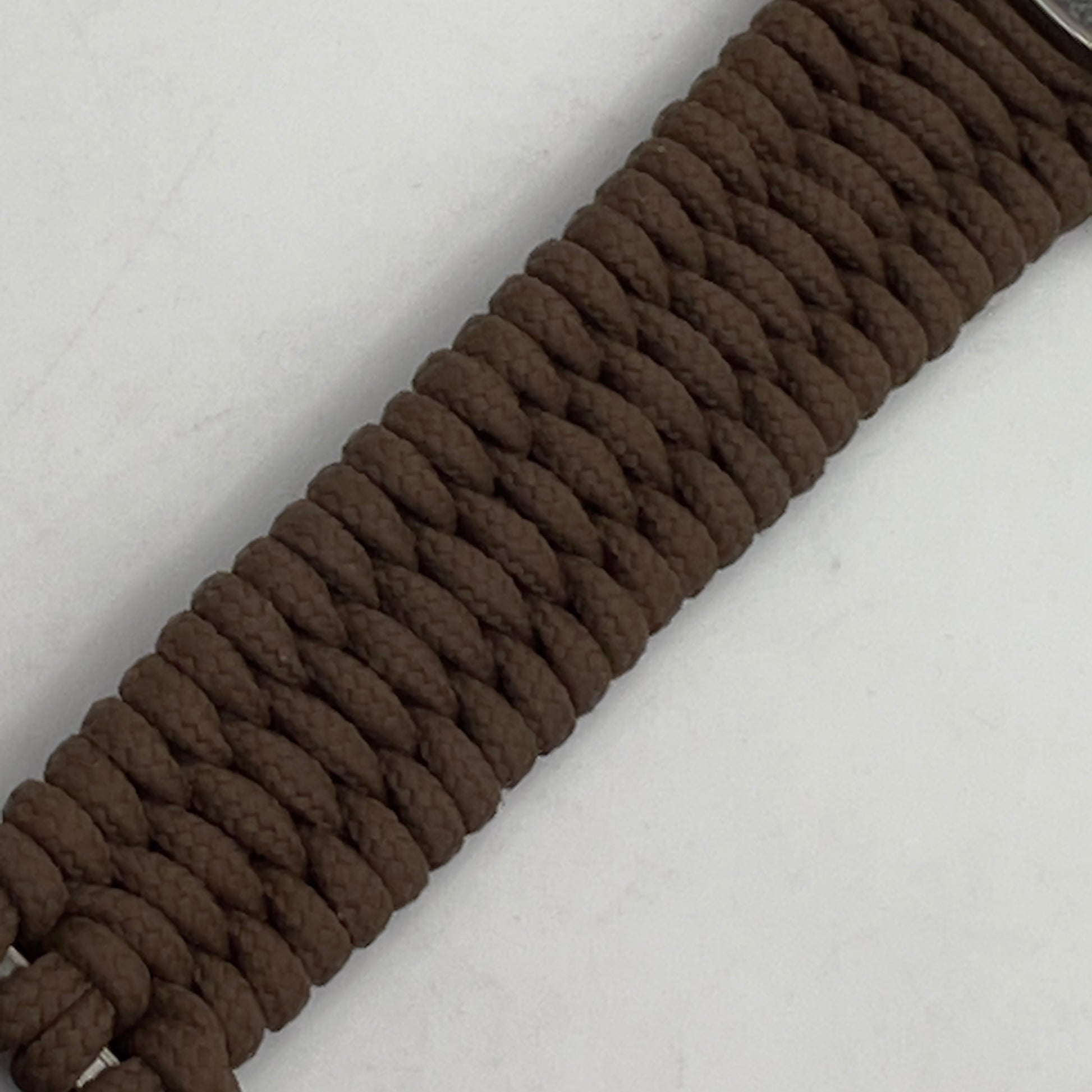 Thin, narrow, flexible and comfortable braided United States Marine Corps Recruit Depot Yellow Footprints bracelet featuring a black nickel plated UV enamel painted medallion replica of an actual set of USMC recruit depot footprints, a gold Cobra style tactical buckle and woven with Coyote Brown type-1 paracord.