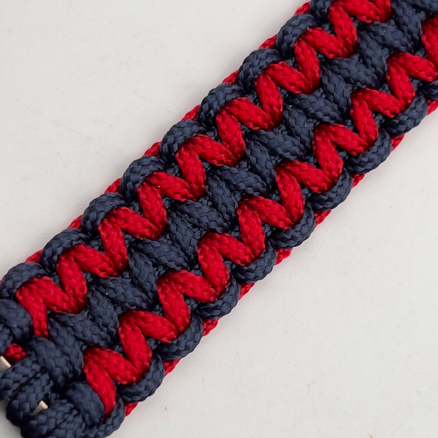 Thin, medium width, flexible and comfortable braided United States Marine Corps bracelet featuring a 24K gold and silver plated USMC officer Eagle Globe and Anchor medallion, a gold Cobra style tactical buckle and woven with Navy Blue and Imperial Red type-1 paracord.