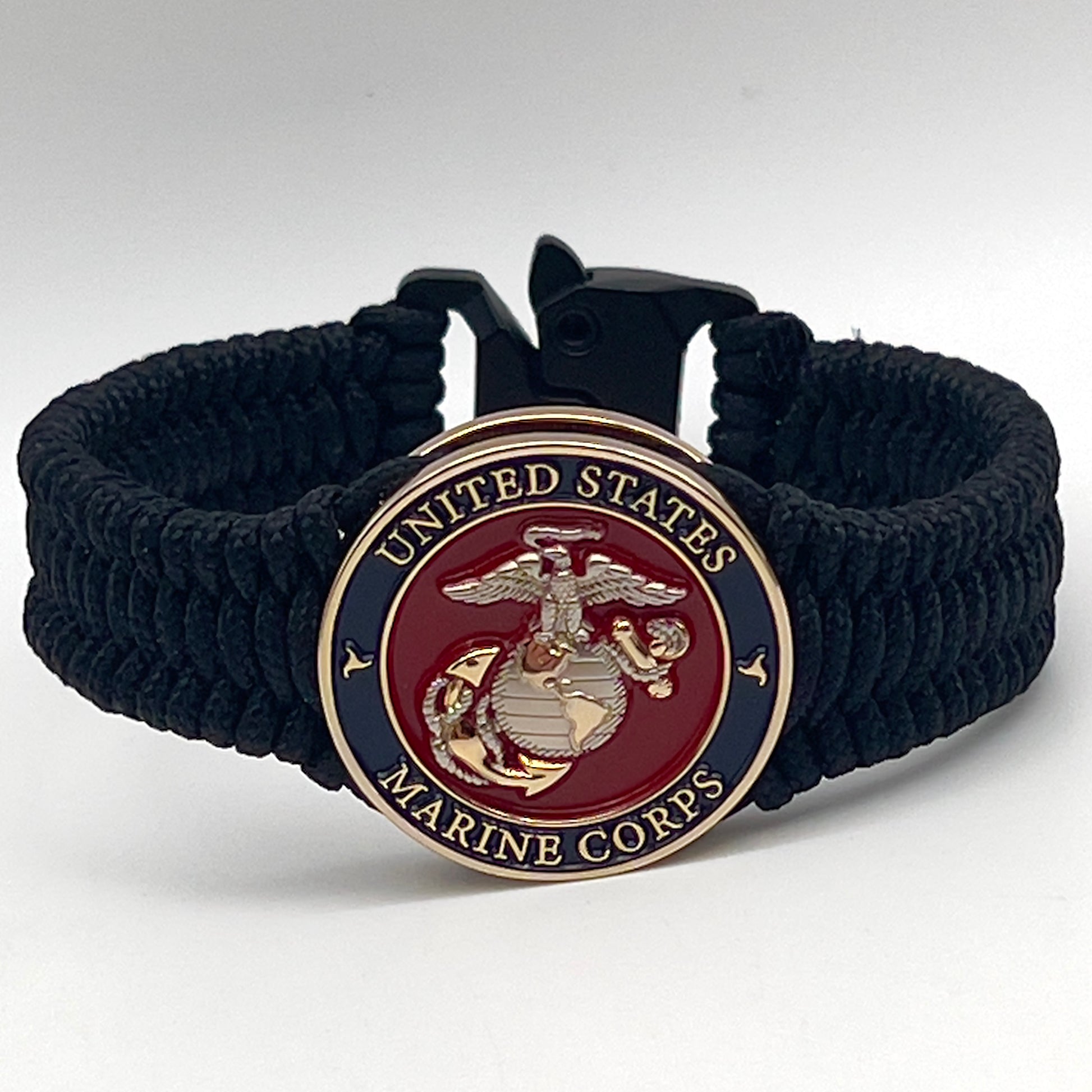 Thin, narrow, flexible and comfortable braided United States Marine Corps bracelet featuring a 24K gold and silver plated USMC Eagle Globe and Anchor medallion, a black Cobra style tactical buckle and woven with black type-1 paracord.