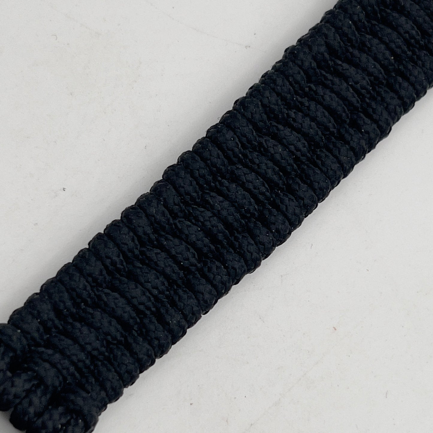 Thin, narrow, flexible and comfortable braided United States Marine Corps bracelet featuring a 24K gold and silver plated USMC Eagle Globe and Anchor medallion, a black Cobra style tactical buckle and woven with black type-1 paracord.