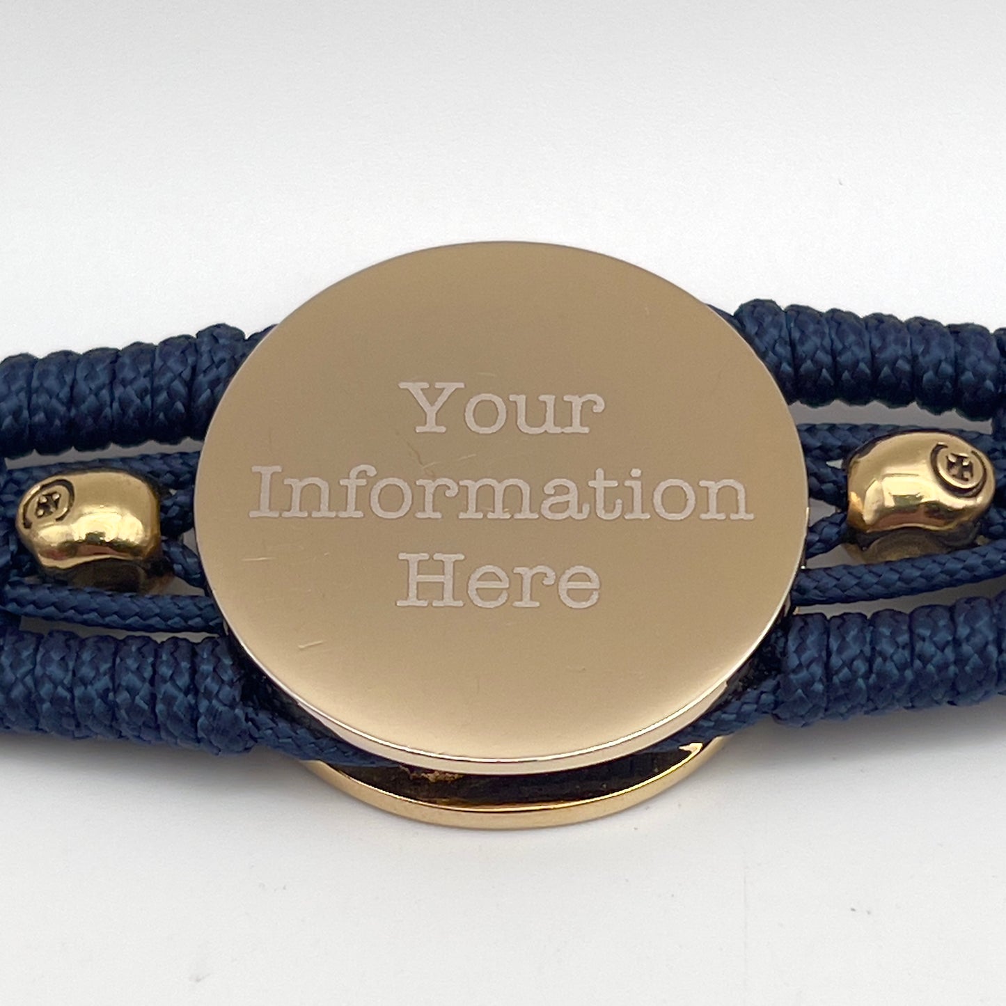 Thin, medium width, flexible and comfortable braided United States Marine Corps bracelet featuring a 24K gold and silver plated USMC officer Eagle Globe and Anchor medallion, two gold micro skulls, a gold Cobra style tactical buckle and woven with Navy blue type-1 paracord.