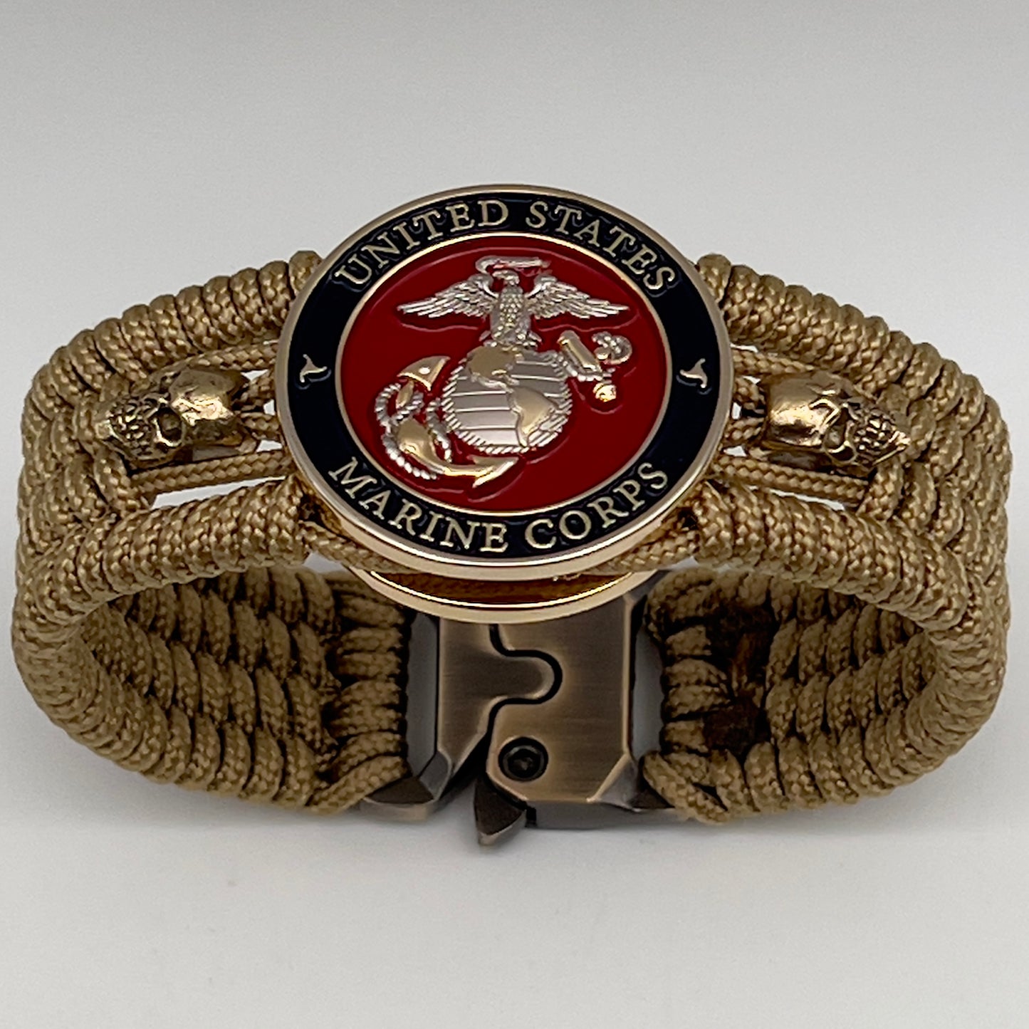 Thin, medium width, flexible and comfortable braided United States Marine Corps bracelet featuring a 24K gold and silver plated USMC officer Eagle Globe and Anchor medallion, two gold micro skulls, a gold Cobra style tactical buckle and woven with gold type-1 paracord.