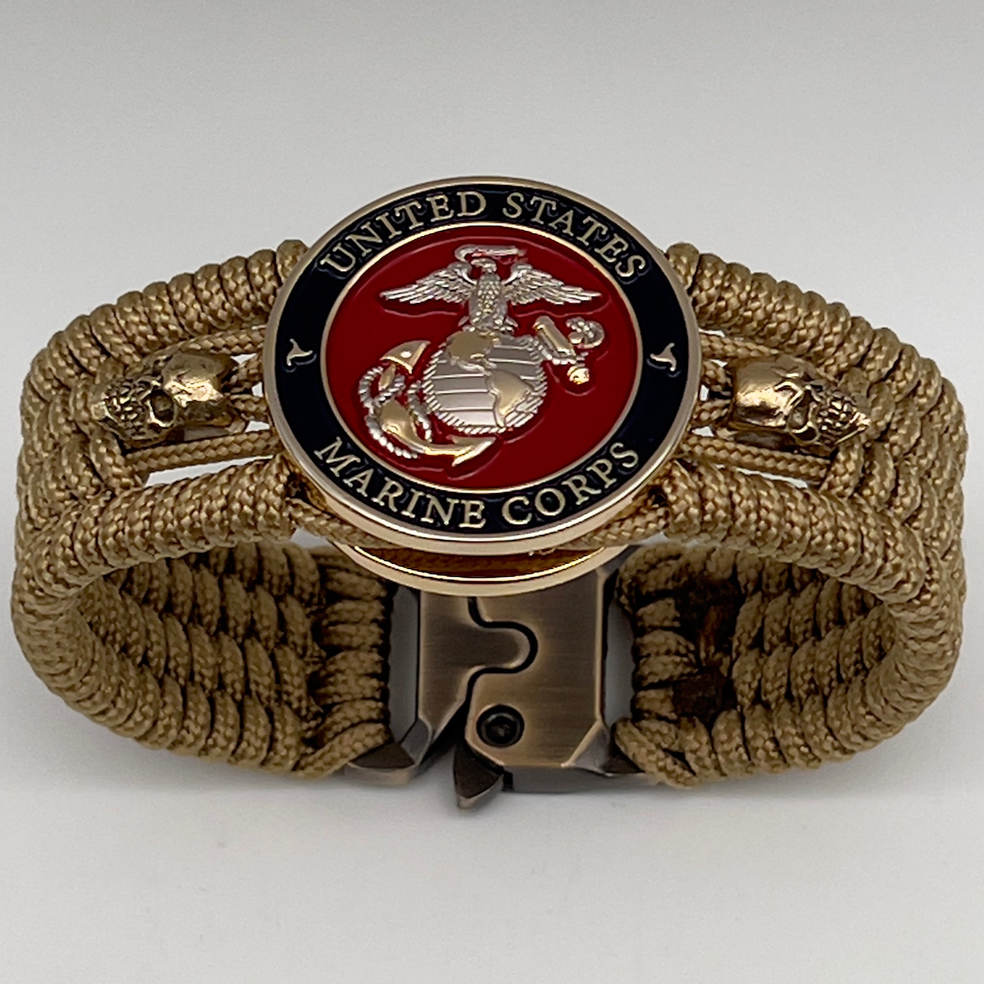 Thin, medium width, flexible and comfortable braided United States Marine Corps bracelet featuring a 24K gold and silver plated USMC officer Eagle Globe and Anchor medallion, two gold micro skulls, a gold Cobra style tactical buckle and woven with gold type-1 paracord.