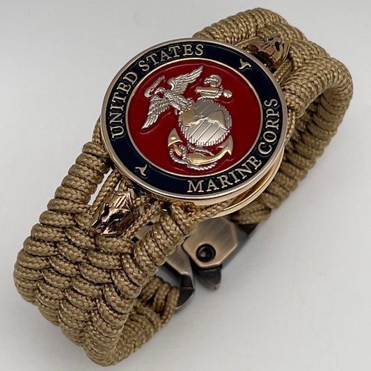 Thin, medium width, flexible and comfortable braided United States Marine Corps bracelet featuring a 24K gold and silver plated USMC officer Eagle Globe and Anchor medallion, two brass micro Spartan helmets, a gold Cobra style tactical buckle and woven with gold type-1 paracord.