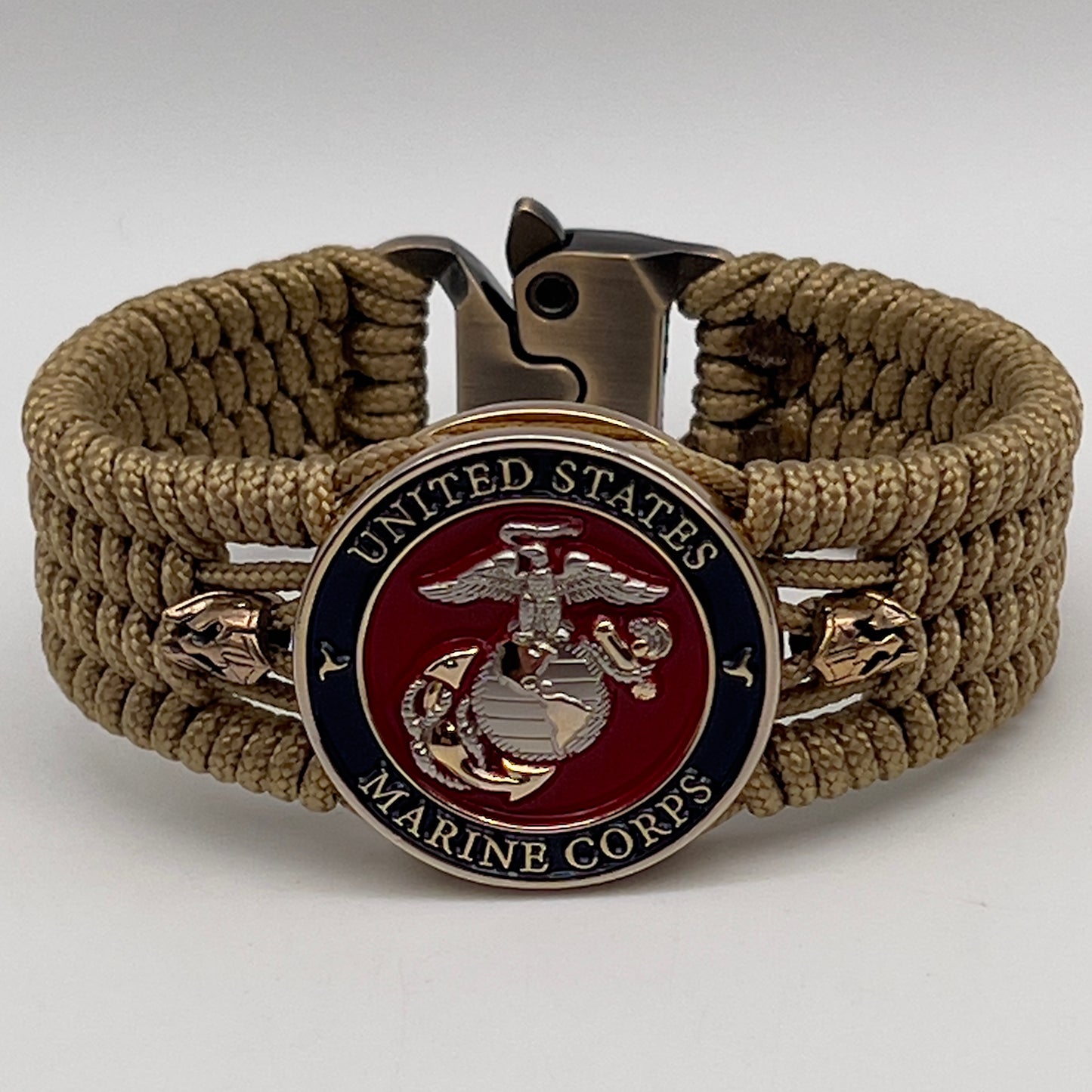 Thin, medium width, flexible and comfortable braided United States Marine Corps bracelet featuring a 24K gold and silver plated USMC officer Eagle Globe and Anchor medallion, two brass micro Spartan helmets, a gold Cobra style tactical buckle and woven with gold type-1 paracord.