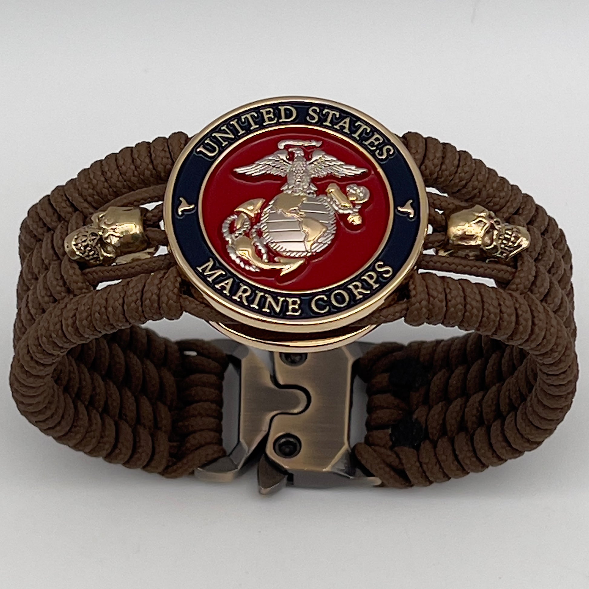 Thin, medium width, flexible and comfortable braided United States Marine Corps bracelet featuring a 24K gold and silver plated USMC officer Eagle Globe and Anchor medallion, two gold micro skulls, a gold Cobra style tactical buckle and woven with Coyote Brown type-1 paracord.