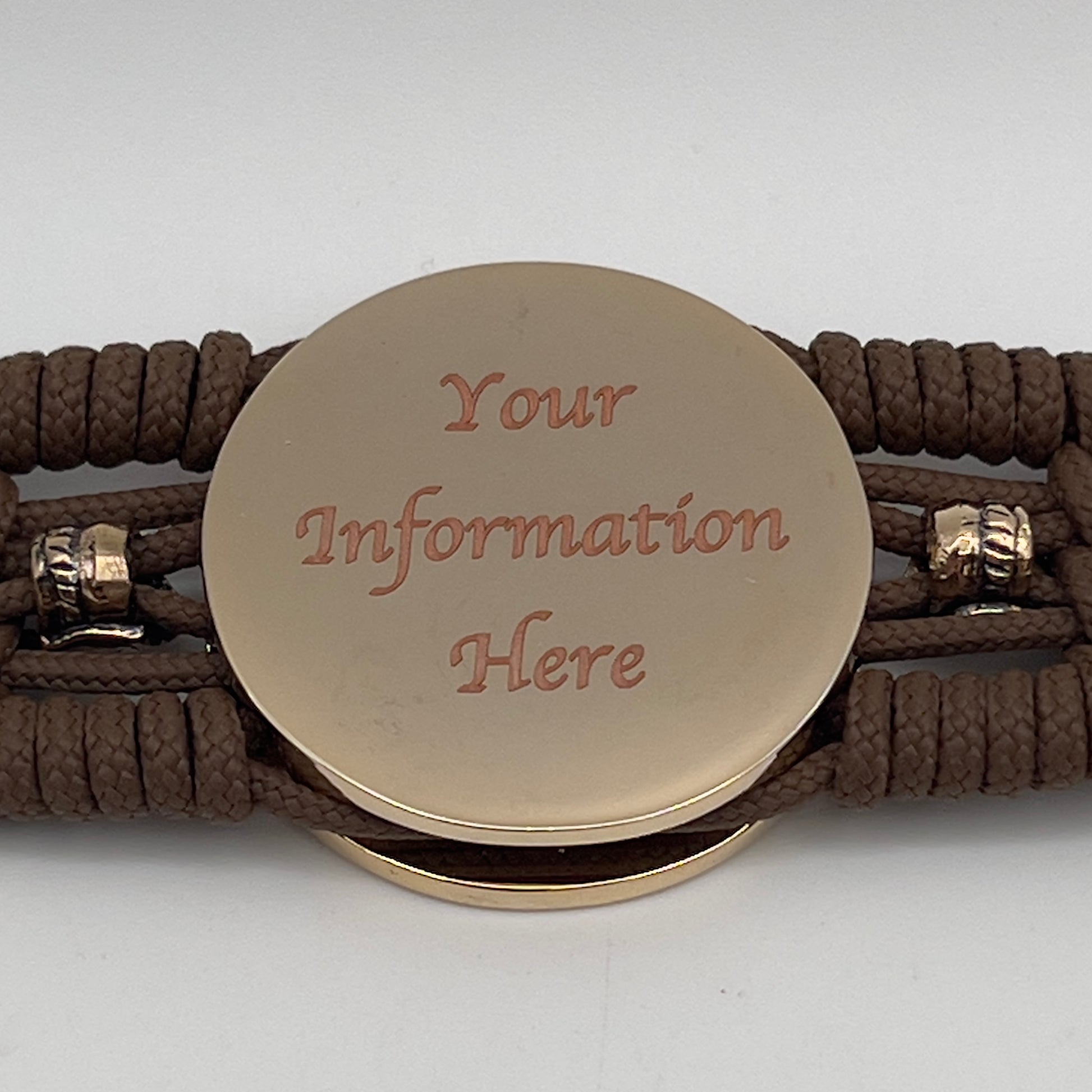 Thin, medium width, flexible and comfortable braided United States Marine Corps bracelet featuring a 24K gold and silver plated USMC officer Eagle Globe and Anchor medallion, two brass micro Spartan helmets, a gold Cobra style tactical buckle and woven with Coyote Brown type-1 paracord.