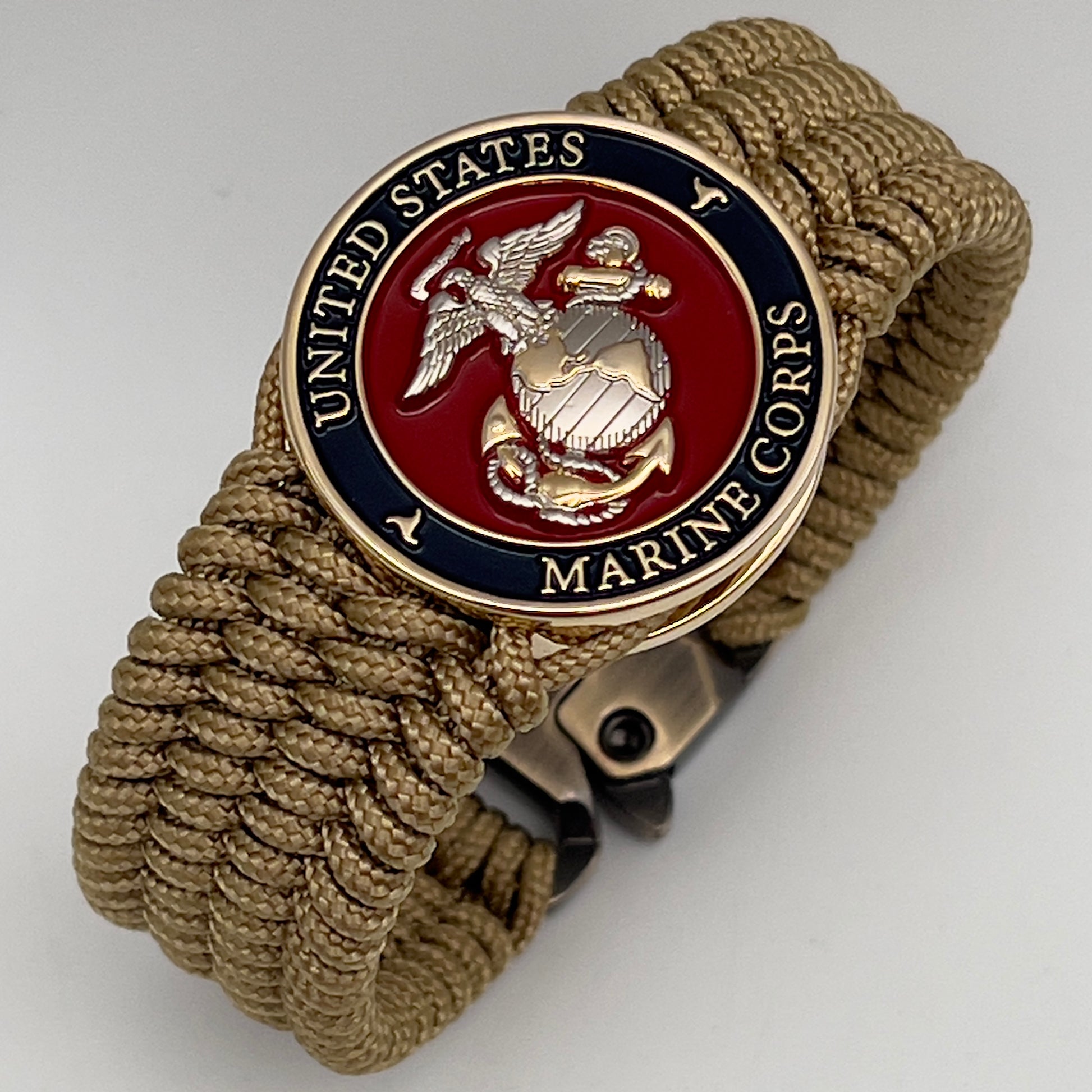 Thin, wide, flexible and comfortable braided United States Marine Corps bracelet featuring a 24K gold and silver plated USMC Eagle Globe and Anchor medallion, a gold Cobra style tactical buckle and woven with gold type-1 paracord.