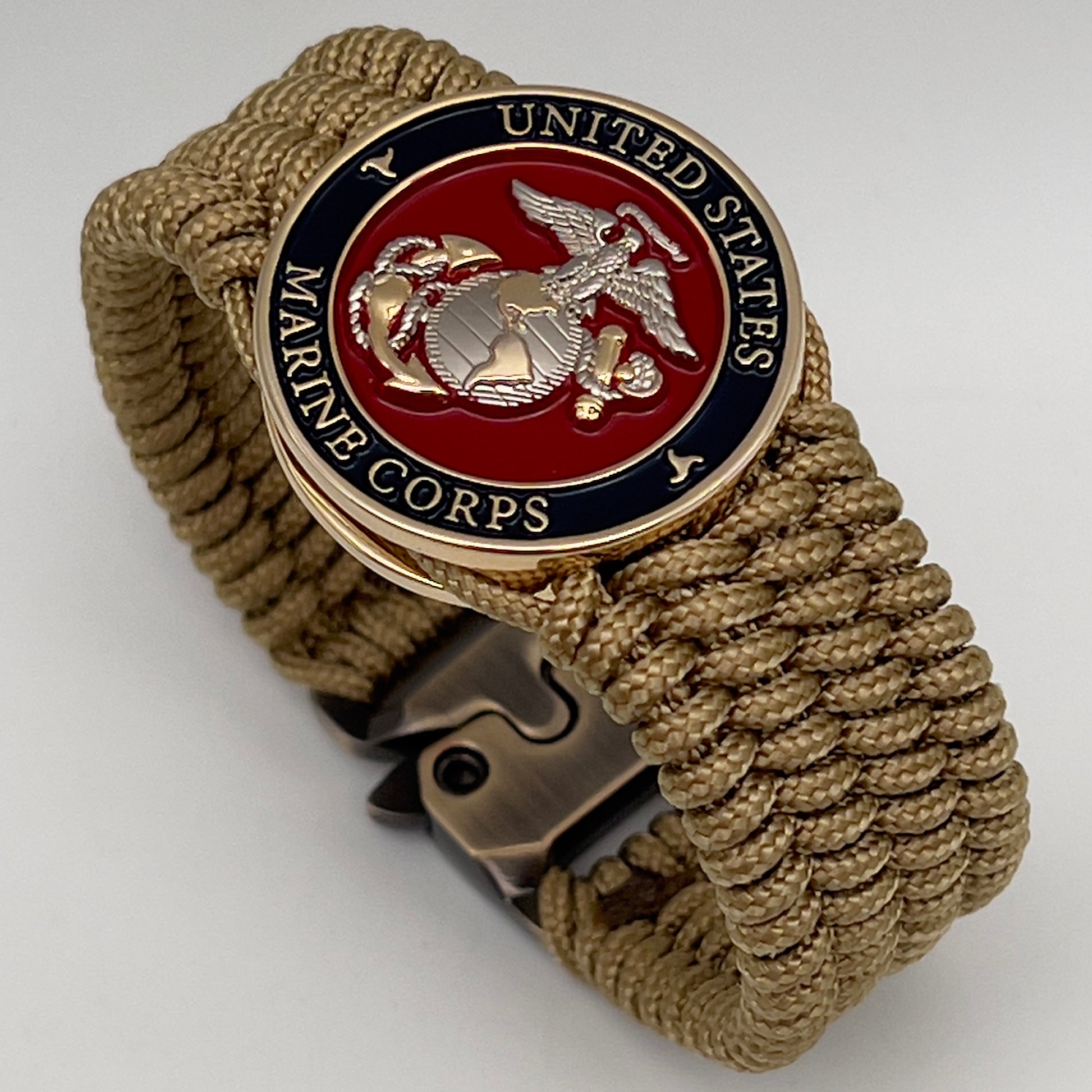 Thin, wide, flexible and comfortable braided United States Marine Corps bracelet featuring a 24K gold and silver plated USMC Eagle Globe and Anchor medallion, a gold Cobra style tactical buckle and woven with gold type-1 paracord.