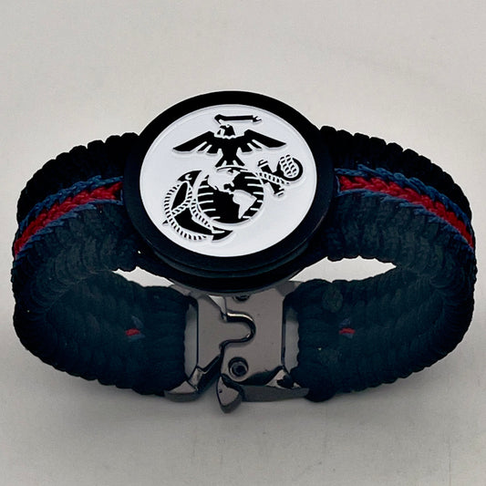 Thin, medium width, flexible and comfortable braided United States Marine Corps bracelet featuring a black USMC Eagle Globe and Anchor medallion, a black Cobra style tactical buckle and woven with black Type-1 paracord and stitched with red and blue nano cord.