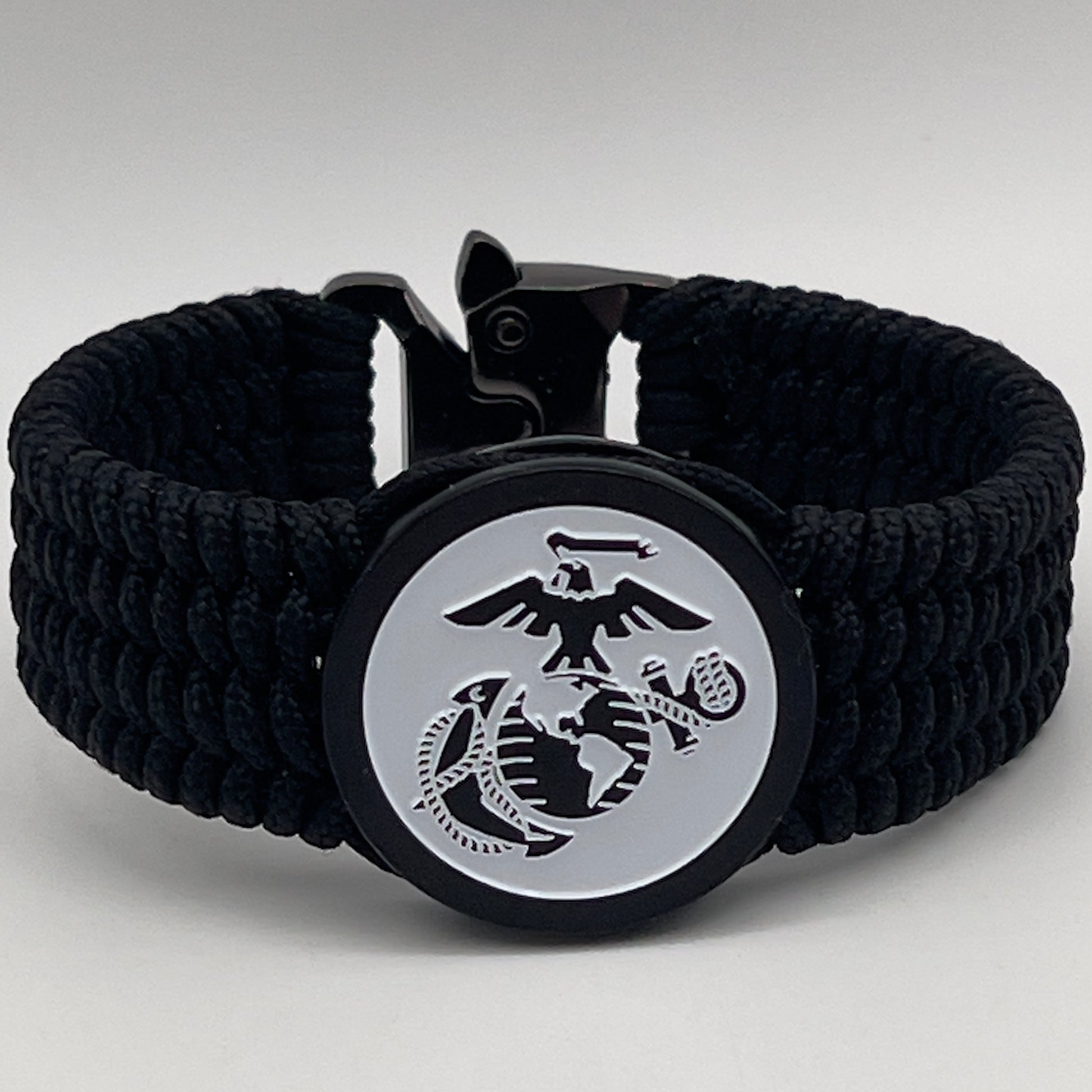 Thin, medium width, flexible and comfortable braided United States Marine Corps bracelet featuring a black USMC Eagle Globe and Anchor medallion, a black Cobra style tactical buckle and woven with black Type-1 paracord.