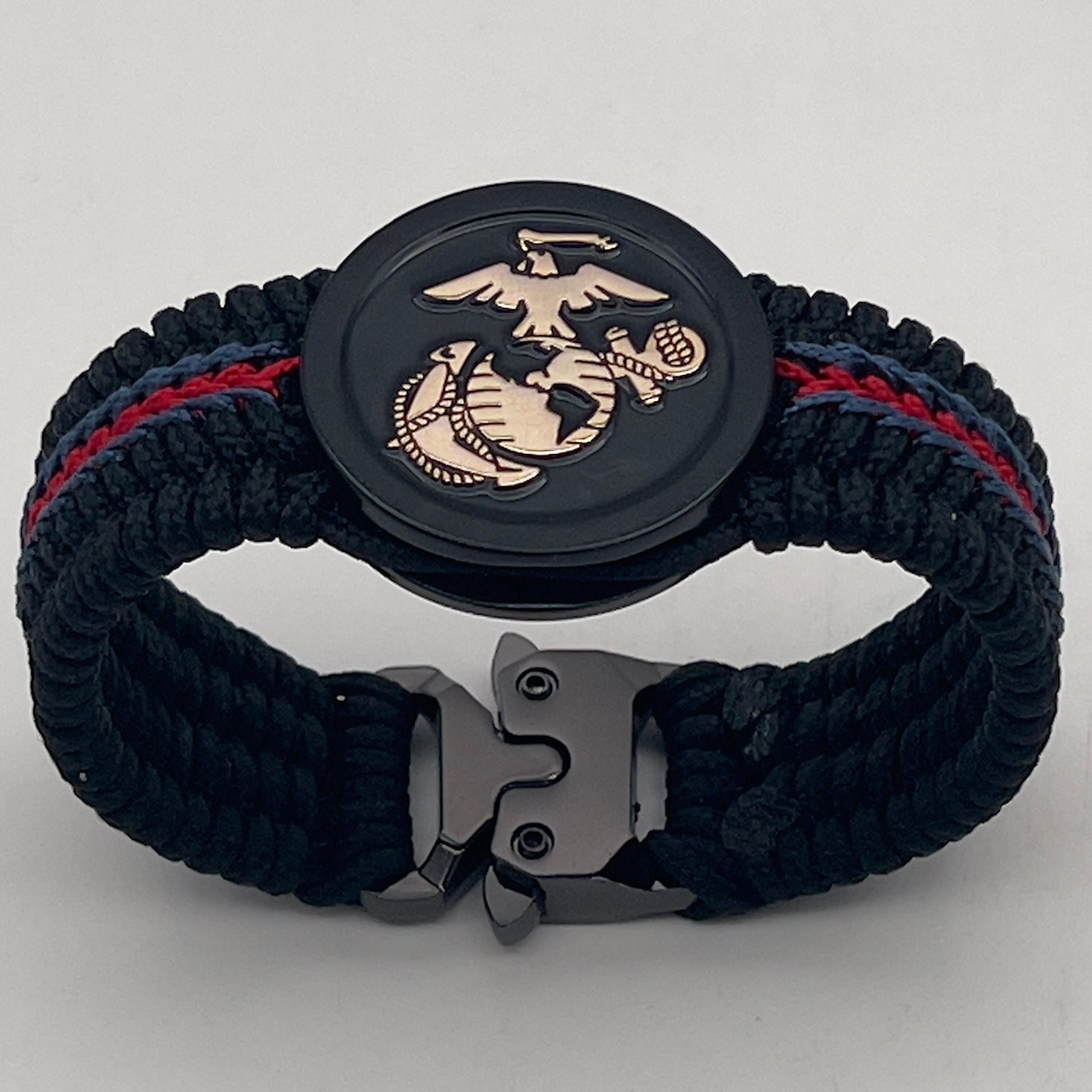 Thin, medium width, flexible and comfortable braided United States Marine Corps bracelet featuring a black USMC Eagle Globe and Anchor medallion, a black Cobra style tactical buckle and woven with black Type-1 paracord and blue and red nano cord.