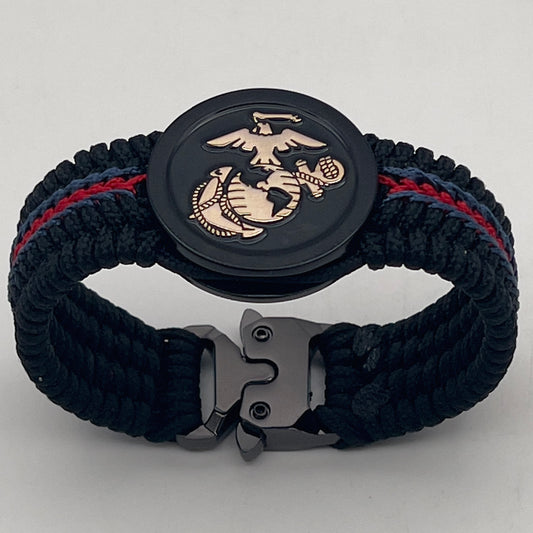 Thin, medium width, flexible and comfortable braided United States Marine Corps bracelet featuring a black USMC Eagle Globe and Anchor medallion, a black Cobra style tactical buckle and woven with black Type-1 paracord and blue and red nano cord.