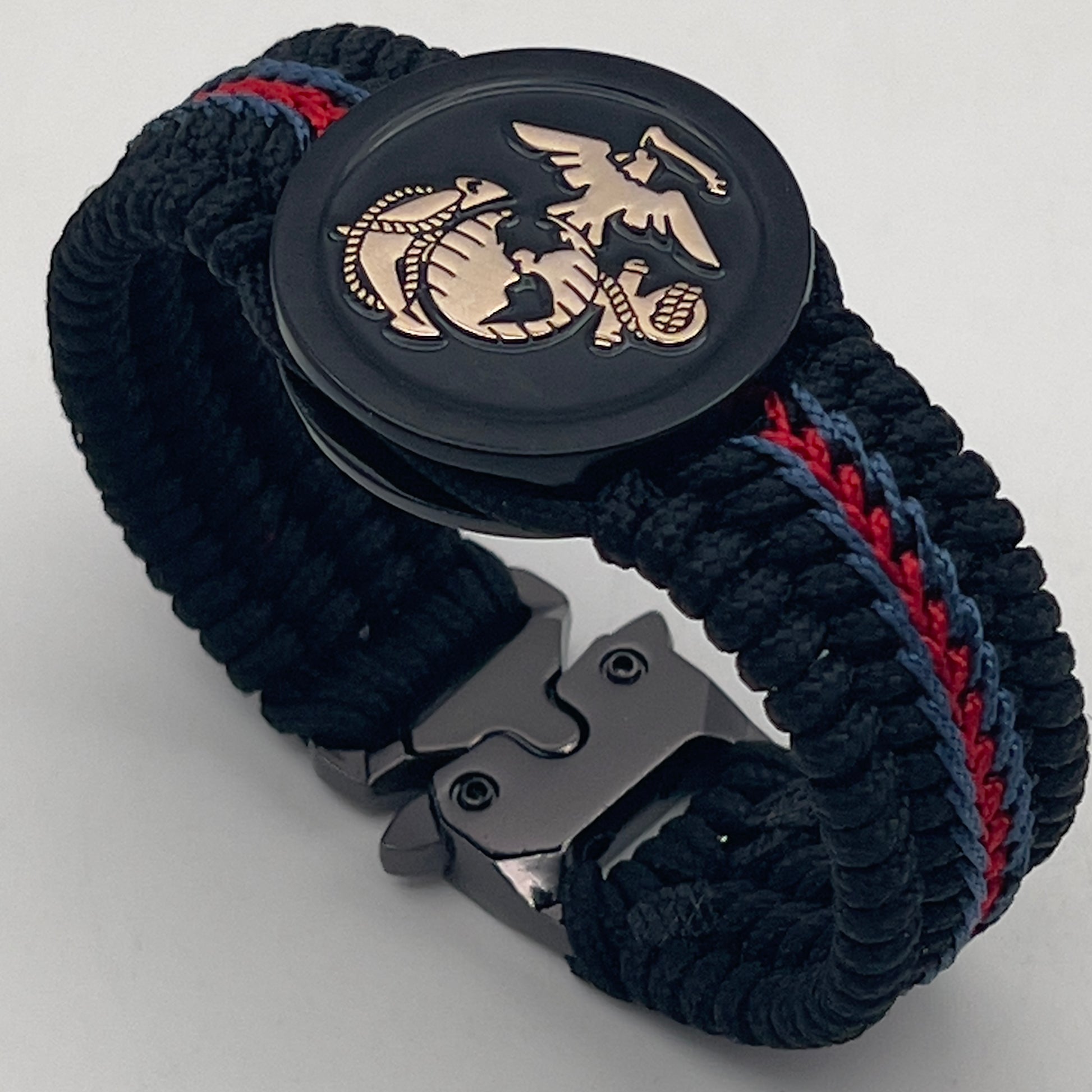 Thin, medium width, flexible and comfortable braided United States Marine Corps bracelet featuring a black USMC Eagle Globe and Anchor medallion, a black Cobra style tactical buckle and woven with black Type-1 paracord and blue and red nano cord.