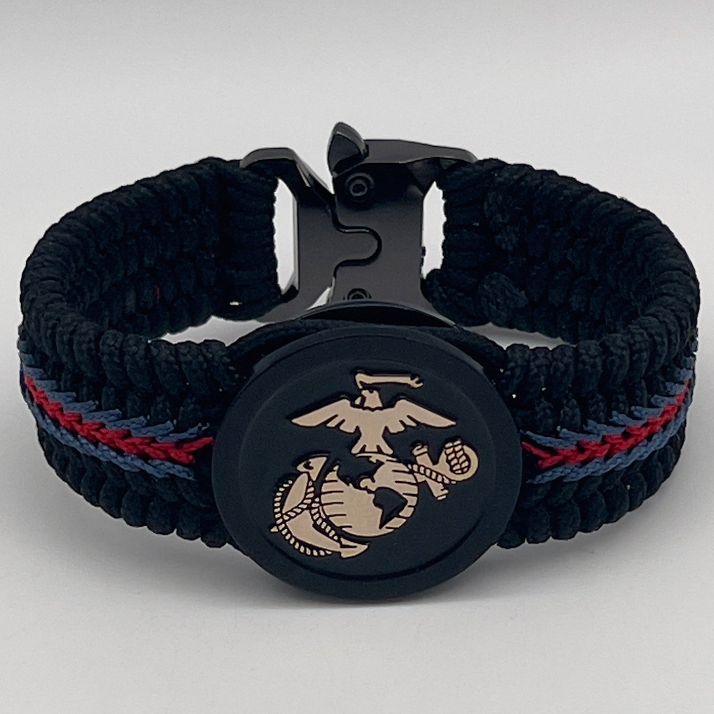 Thin, medium width, flexible and comfortable braided United States Marine Corps bracelet featuring a black USMC Eagle Globe and Anchor medallion, a black Cobra style tactical buckle and woven with black Type-1 paracord and blue and red nano cord.