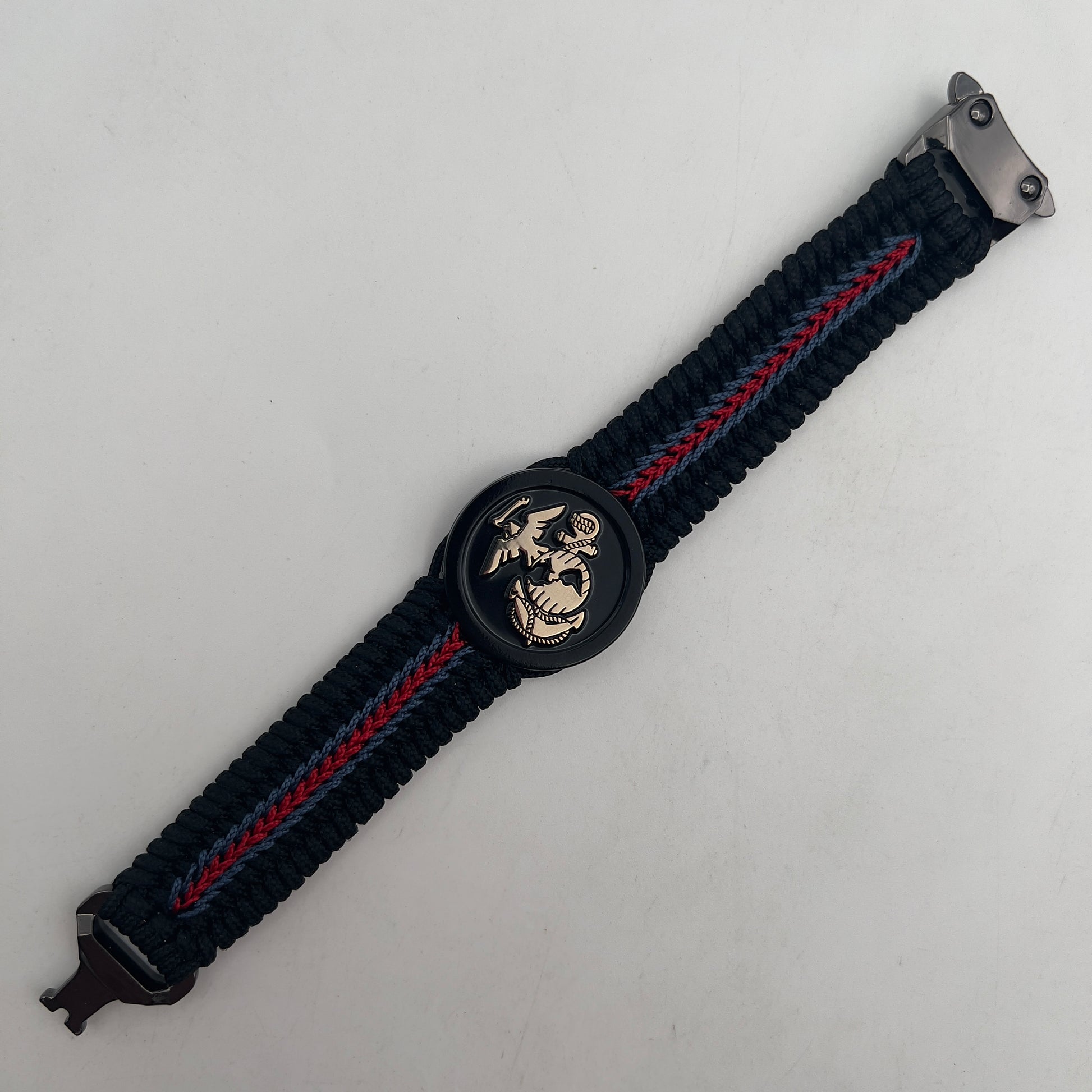 Thin, medium width, flexible and comfortable braided United States Marine Corps bracelet featuring a black USMC Eagle Globe and Anchor medallion, a black Cobra style tactical buckle and woven with black Type-1 paracord and blue and red nano cord.