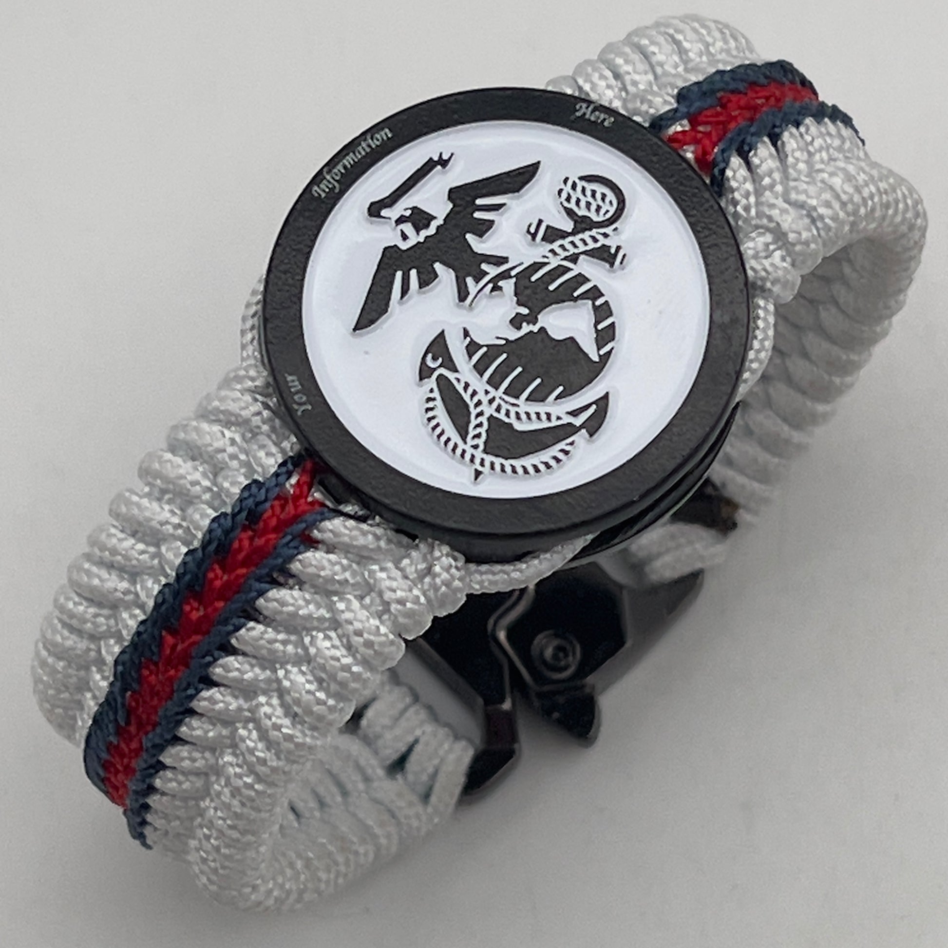 Thin, medium width, flexible and comfortable braided United States Marine Corps bracelet featuring a black USMC Eagle Globe and Anchor medallion, a black Cobra style tactical buckle and woven with white Type-1 paracord and stitched with red and blue nano cord.