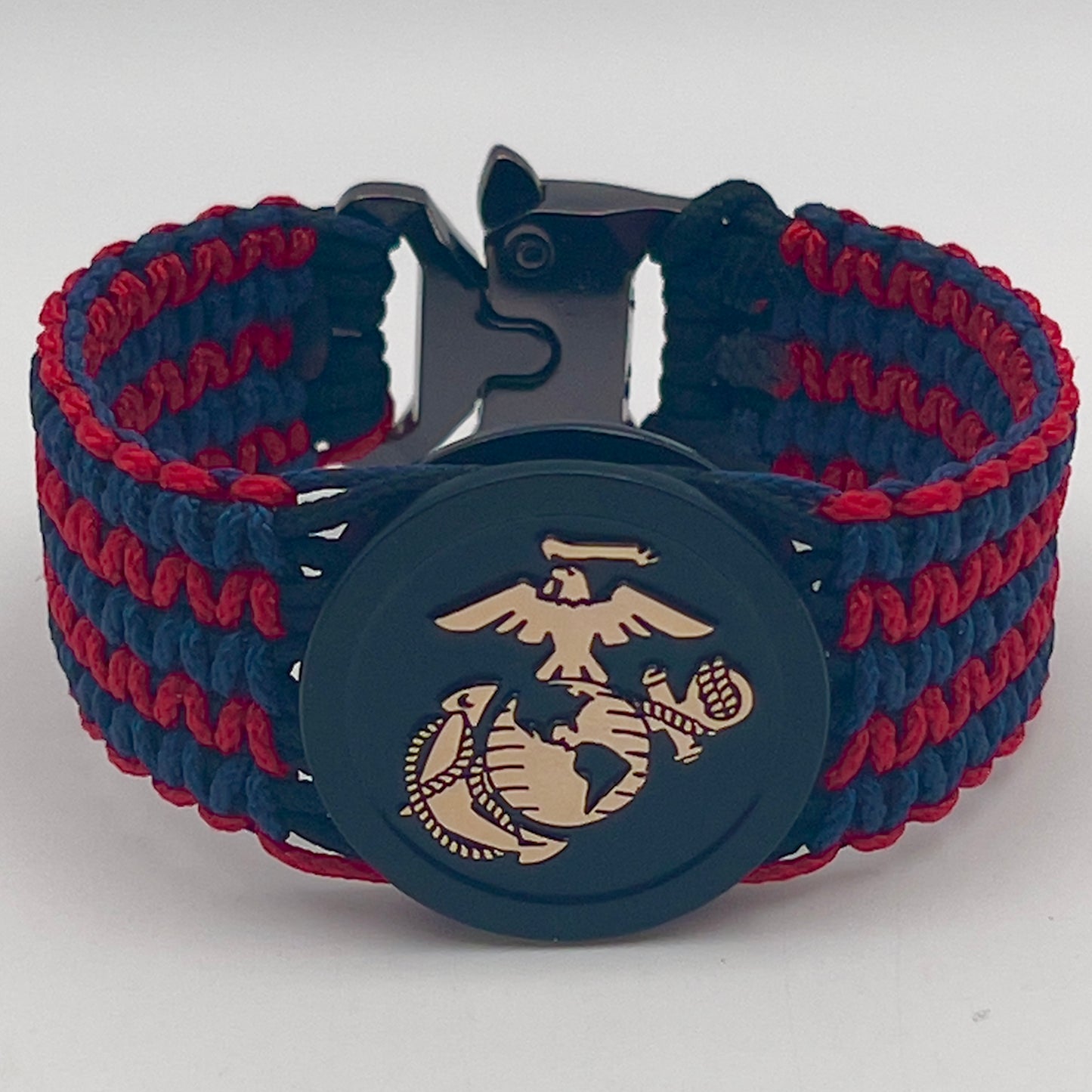 Thin, medium width, flexible and comfortable braided United States Marine Corps bracelet featuring a black USMC Eagle Globe and Anchor medallion, a black Cobra style tactical buckle and woven with black Type-1 paracord and blue and red nano cord.