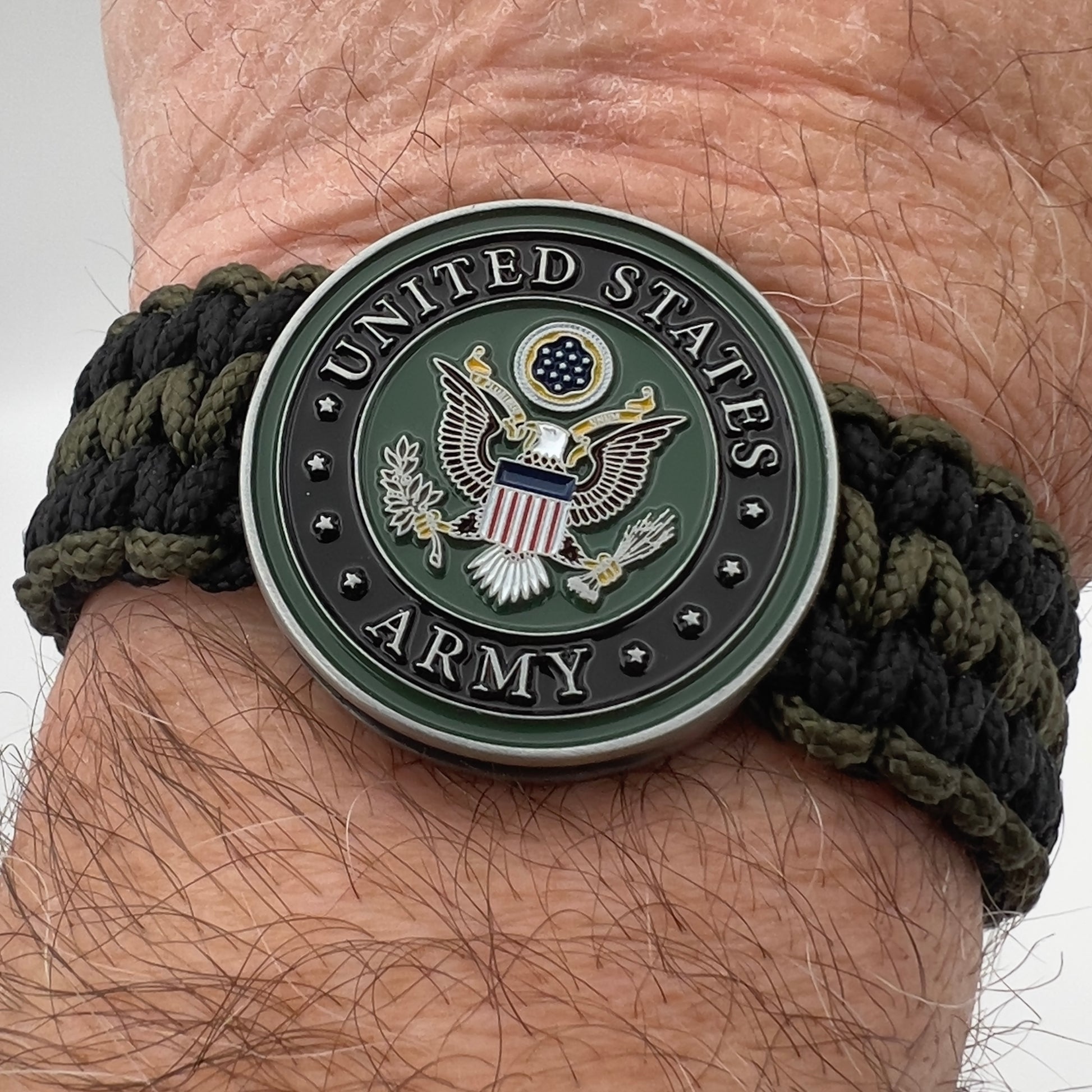 Thin, narrow, flexible and comfortable braided United States Army bracelet featuring an official US Army medallion, a black Cobra style tactical buckle and woven with black and olive drab Type-1 paracord.