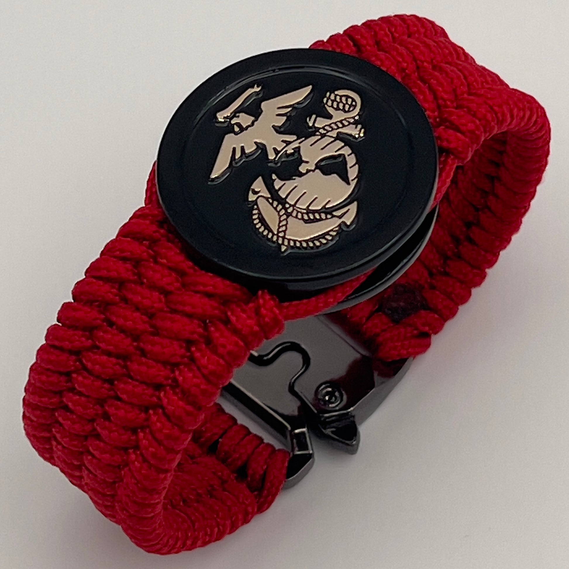 Thin, medium width, flexible and comfortable braided United States Marine Corps bracelet featuring a 24K gold USMC Eagle Globe and Anchor medallion, a black Cobra style tactical buckle and woven with red Type-1 paracord.
