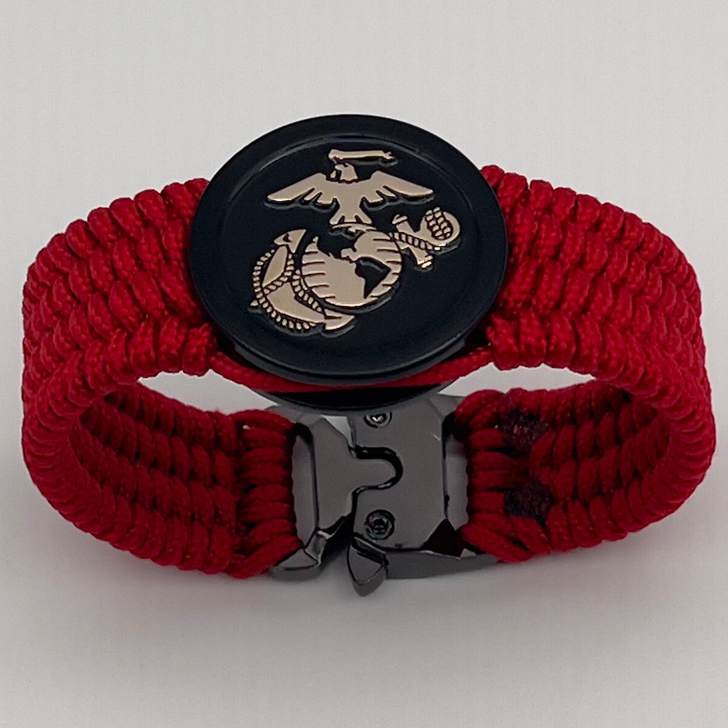 Thin, medium width, flexible and comfortable braided United States Marine Corps bracelet featuring a 24K gold USMC Eagle Globe and Anchor medallion, a black Cobra style tactical buckle and woven with red Type-1 paracord.