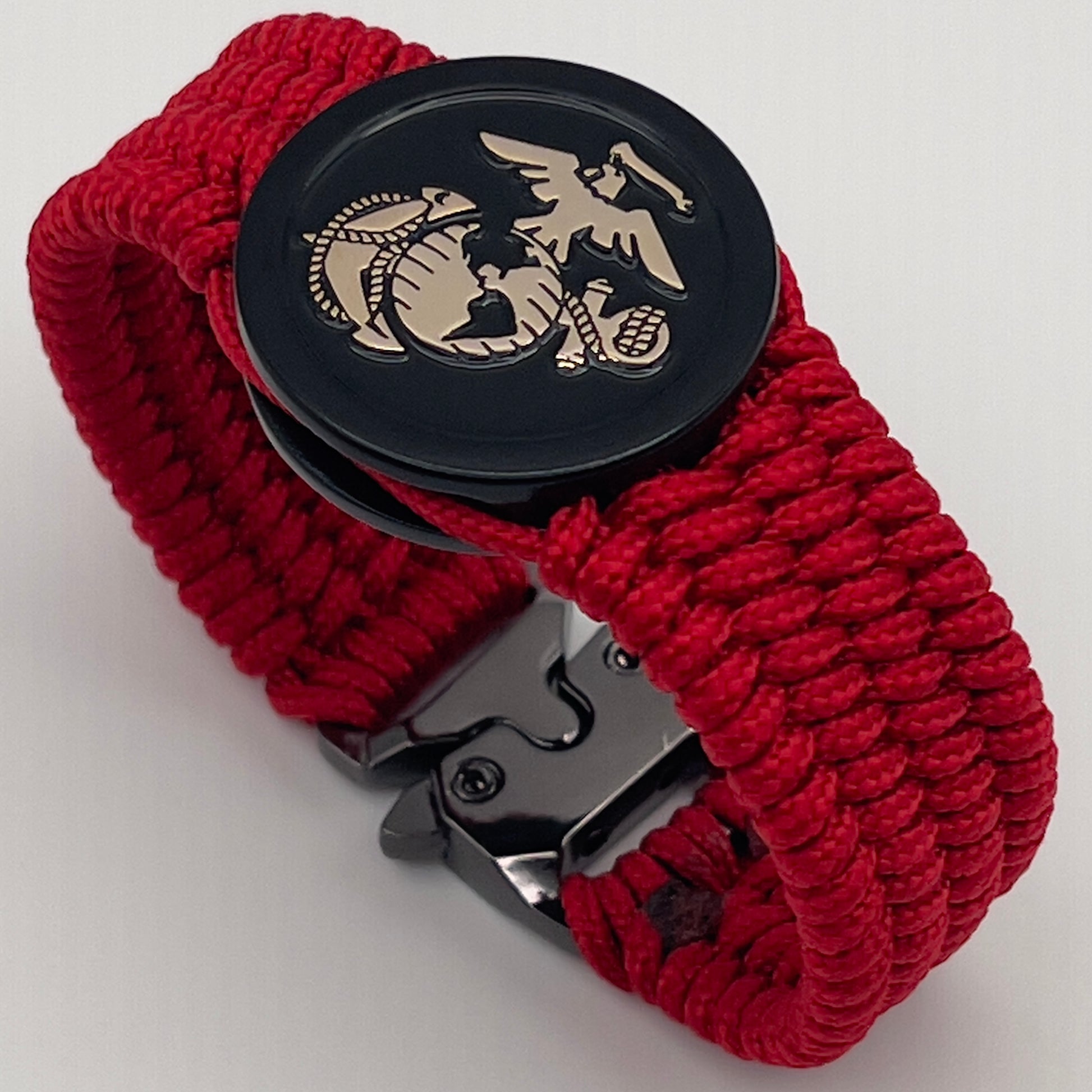 Thin, medium width, flexible and comfortable braided United States Marine Corps bracelet featuring a 24K gold USMC Eagle Globe and Anchor medallion, a black Cobra style tactical buckle and woven with red Type-1 paracord.