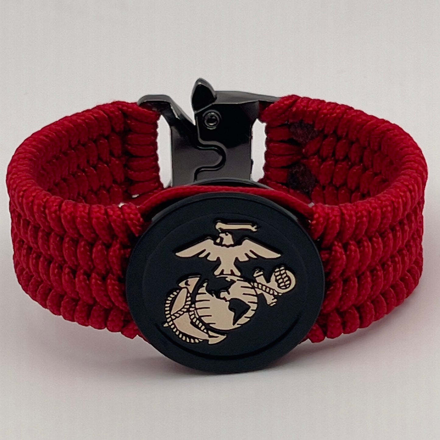 Thin, medium width, flexible and comfortable braided United States Marine Corps bracelet featuring a 24K gold USMC Eagle Globe and Anchor medallion, a black Cobra style tactical buckle and woven with red Type-1 paracord.