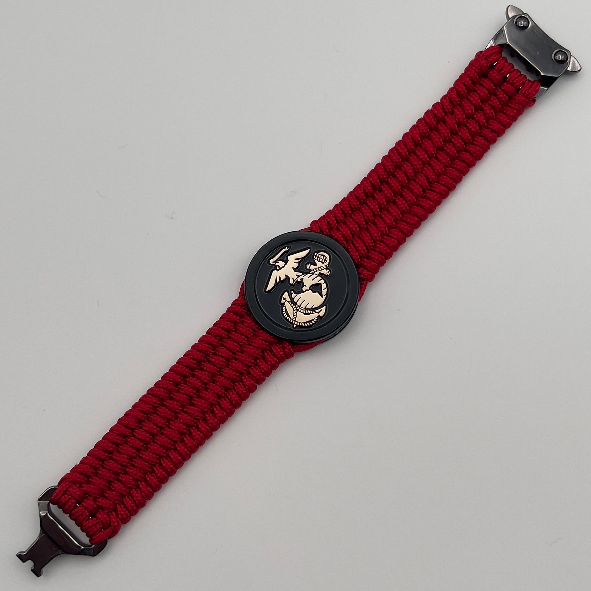 Thin, medium width, flexible and comfortable braided United States Marine Corps bracelet featuring a 24K gold USMC Eagle Globe and Anchor medallion, a black Cobra style tactical buckle and woven with red Type-1 paracord.