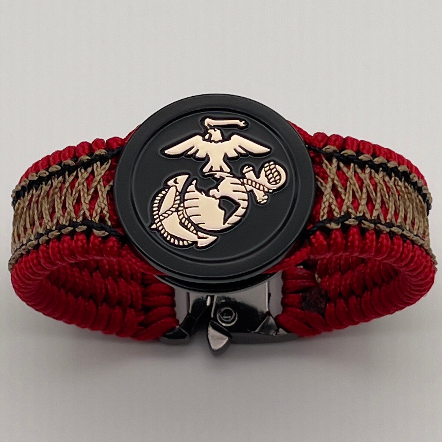Thin, narrow, flexible and comfortable braided United States Marine Corps bracelet featuring the official US Marine Corps Eagle, Globe and Anchor medallion, a black Cobra style tactical buckle and woven with red Type-1 paracord and center stitched with black and gold nano cord.