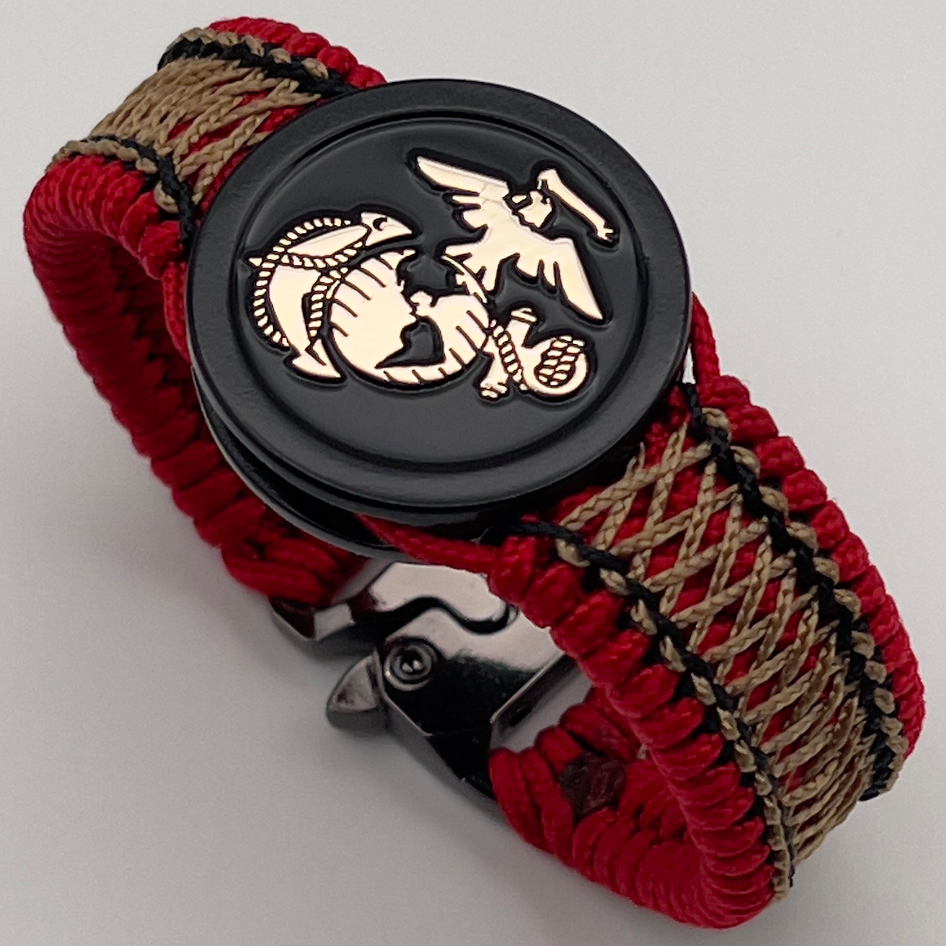 Thin, narrow, flexible and comfortable braided United States Marine Corps bracelet featuring the official US Marine Corps Eagle, Globe and Anchor medallion, a black Cobra style tactical buckle and woven with red Type-1 paracord and center stitched with black and gold nano cord.