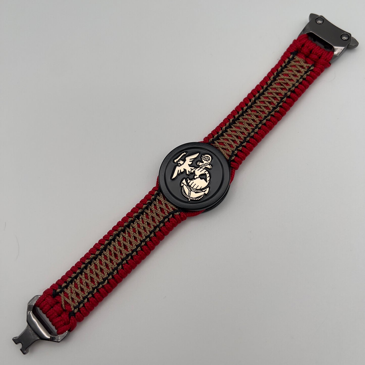 Thin, narrow, flexible and comfortable braided United States Marine Corps bracelet featuring the official US Marine Corps Eagle, Globe and Anchor medallion, a black Cobra style tactical buckle and woven with red Type-1 paracord and center stitched with black and gold nano cord.