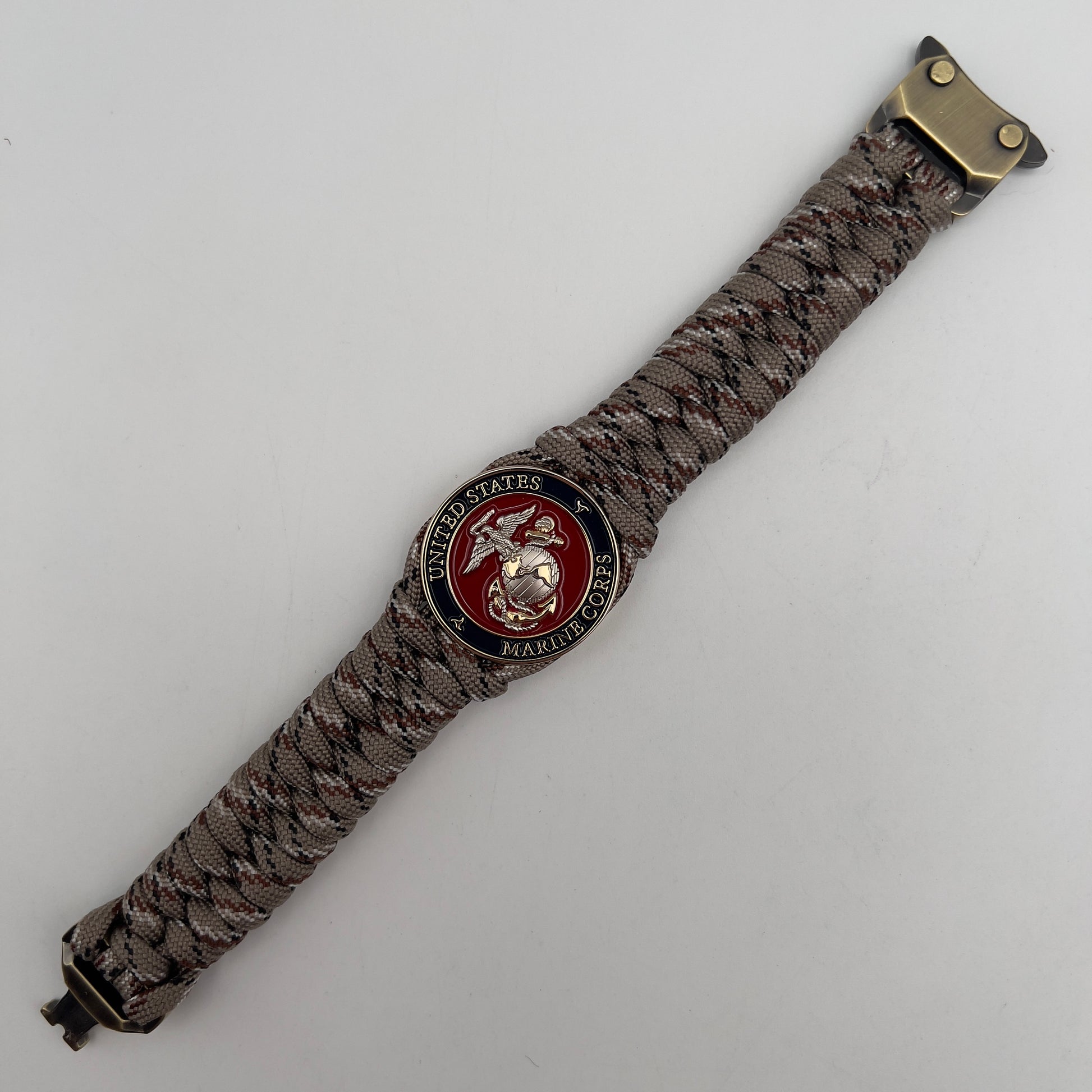 Thick and comfortable braided United States Marine Corps bracelet featuring a 24K gold and silver plated USMC officer Eagle Globe and Anchor medallion, a Cobra style tactical buckle and woven with Desert Camo paracord.