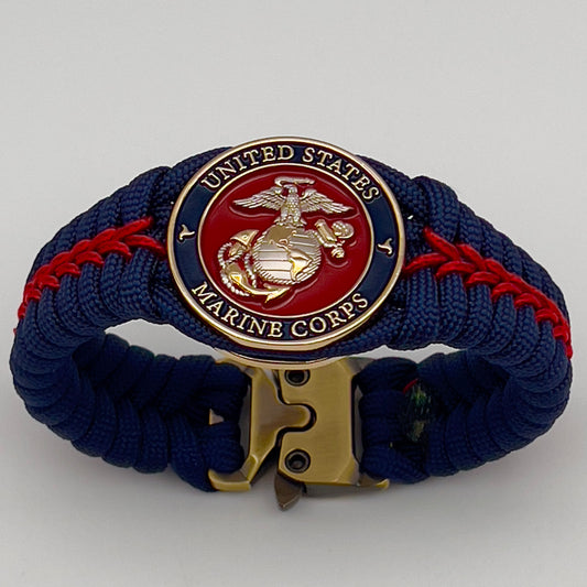 Thick and comfortable braided United States Marine Corps bracelet featuring a 24K gold and silver plated USMC officer Eagle Globe and Anchor medallion, a Cobra style tactical buckle and woven with Navy blue and Imperial red paracord.