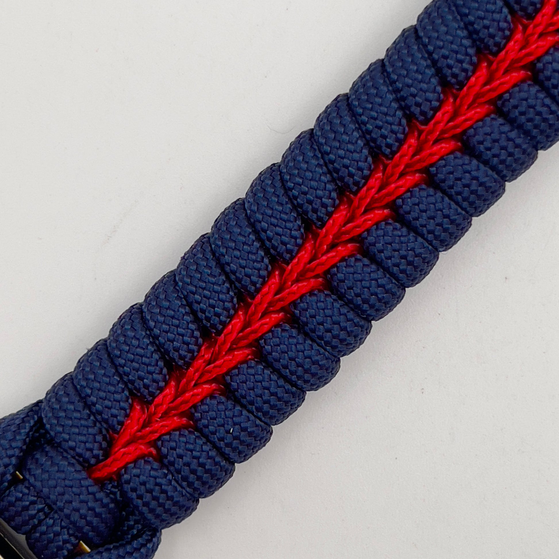Thick and comfortable braided United States Marine Corps bracelet featuring a 24K gold and silver plated USMC officer Eagle Globe and Anchor medallion, a Cobra style tactical buckle and woven with Navy blue and Imperial red paracord.