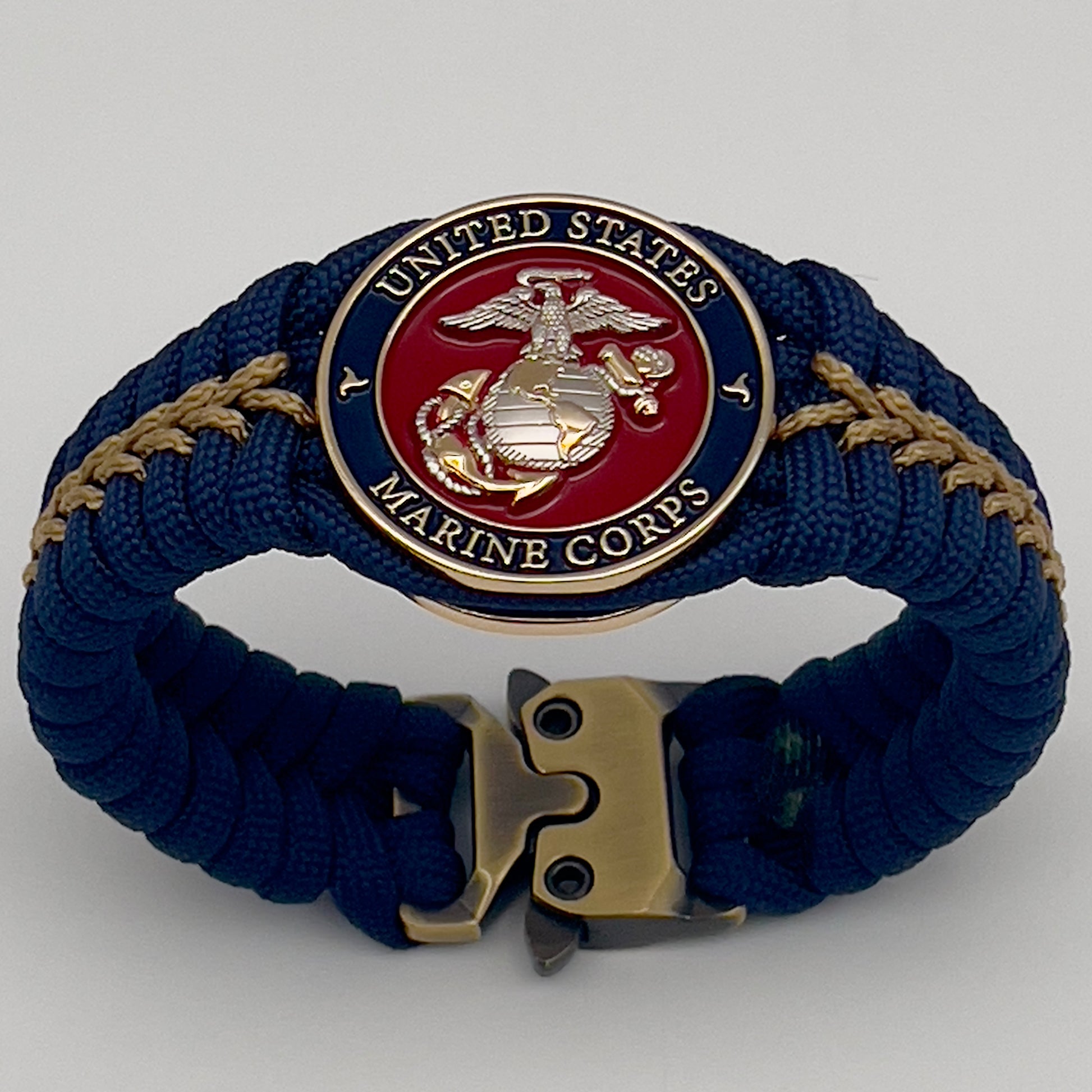 Thick and comfortable braided United States Marine Corps bracelet featuring a 24K gold and silver plated USMC officer Eagle Globe and Anchor medallion, a Cobra style tactical buckle and woven with Navy blue and gold paracord.