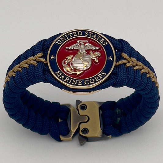 Thick and comfortable braided United States Marine Corps bracelet featuring a 24K gold and silver plated USMC officer Eagle Globe and Anchor medallion, a Cobra style tactical buckle and woven with Navy blue and gold paracord.
