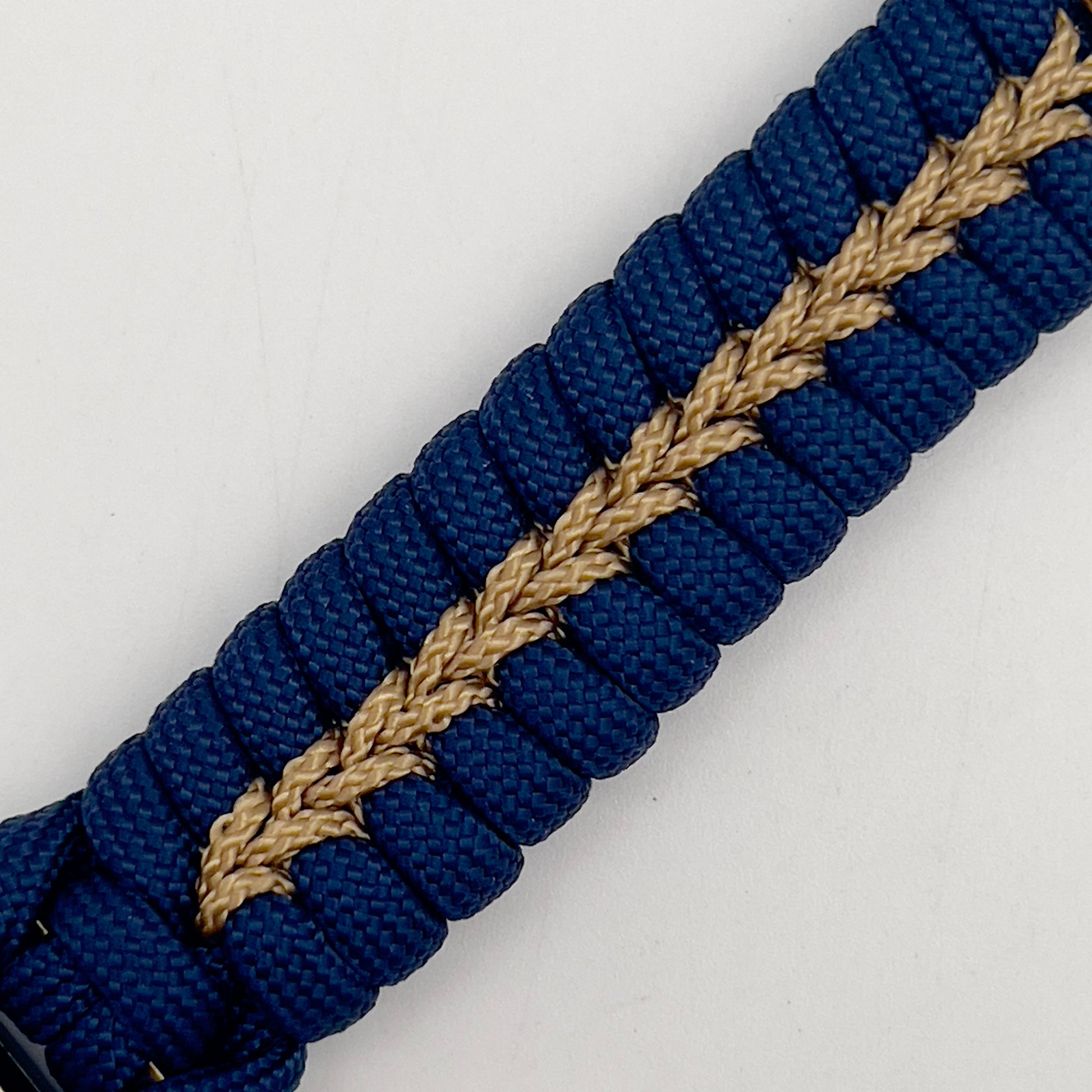 Thick and comfortable braided United States Marine Corps bracelet featuring a 24K gold and silver plated USMC officer Eagle Globe and Anchor medallion, a Cobra style tactical buckle and woven with Navy blue and gold paracord.