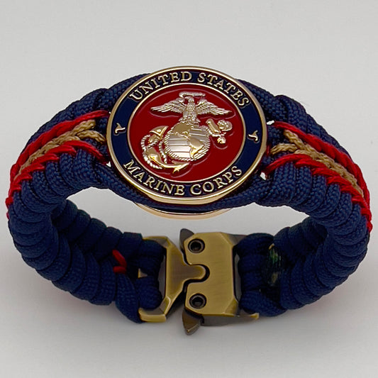 Thick and comfortable braided United States Marine Corps bracelet featuring a 24K gold and silver plated USMC officer Eagle Globe and Anchor medallion, a Cobra style tactical buckle and woven with Navy blue, Imperial red and gold paracord.