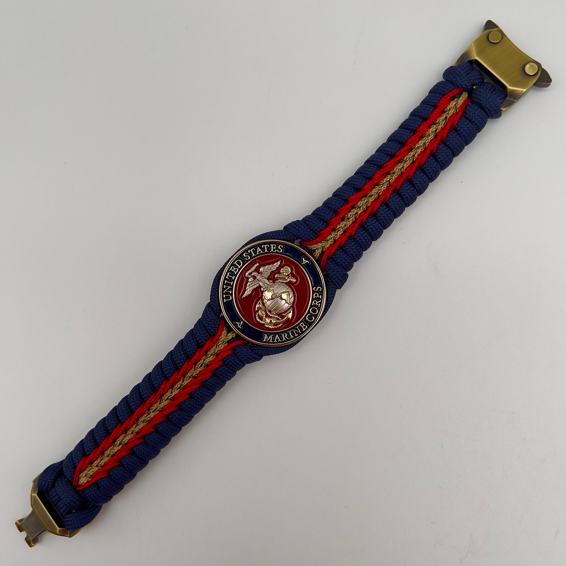 Thick and comfortable braided United States Marine Corps bracelet featuring a 24K gold and silver plated USMC officer Eagle Globe and Anchor medallion, a Cobra style tactical buckle and woven with Navy blue, Imperial red and gold paracord.